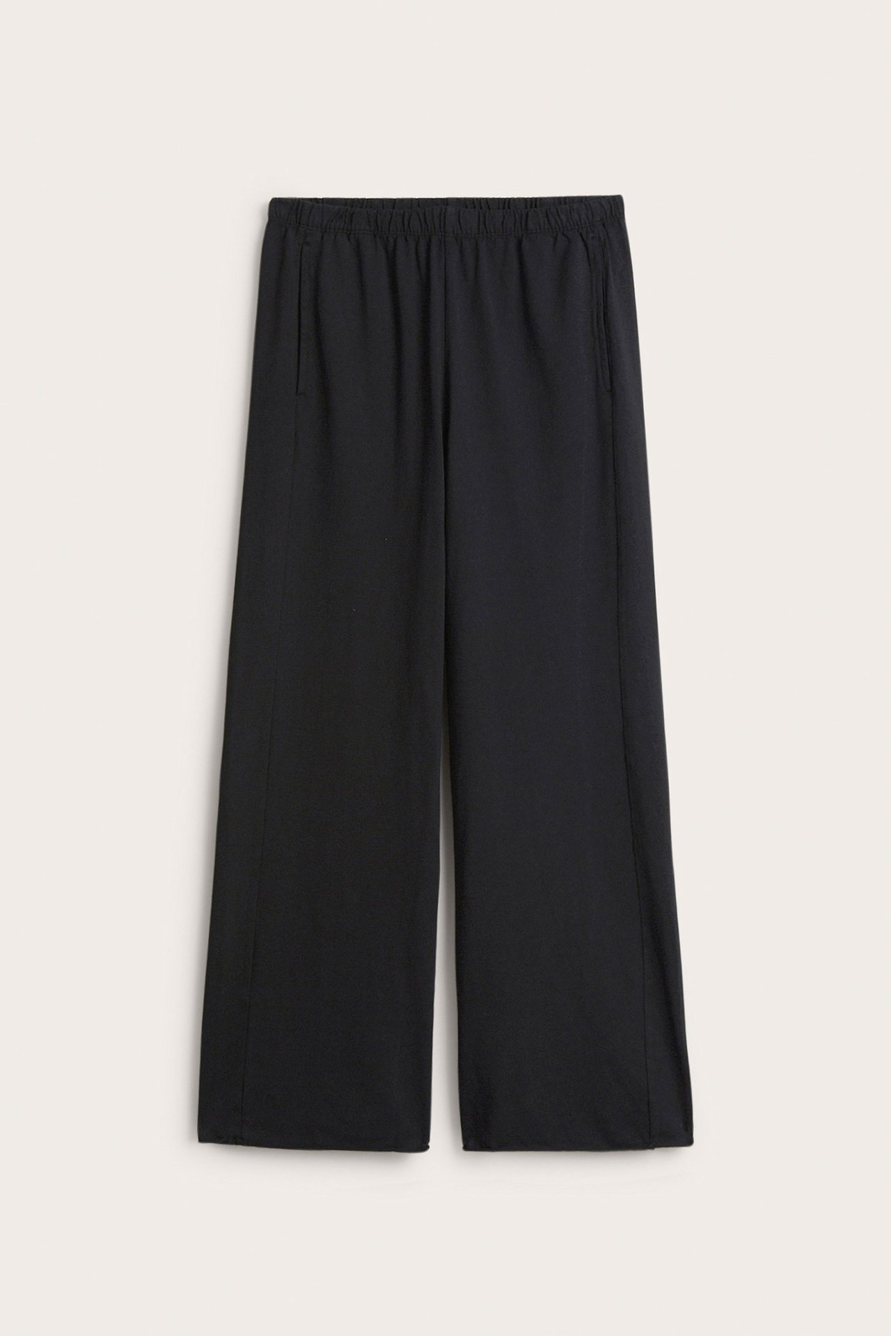 Frontbilde av svarte, rette lounge-joggebukser i bomullsjersey med elastisk midje og sidelommer.