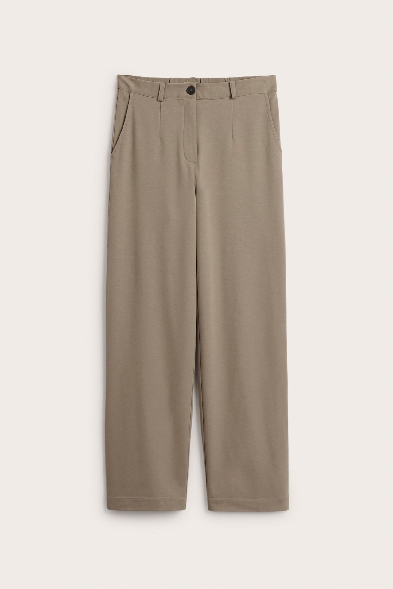 Frontvisning av mørk beige ensfargede Punto Jersey dressbukser med vide ben og knappelukking.