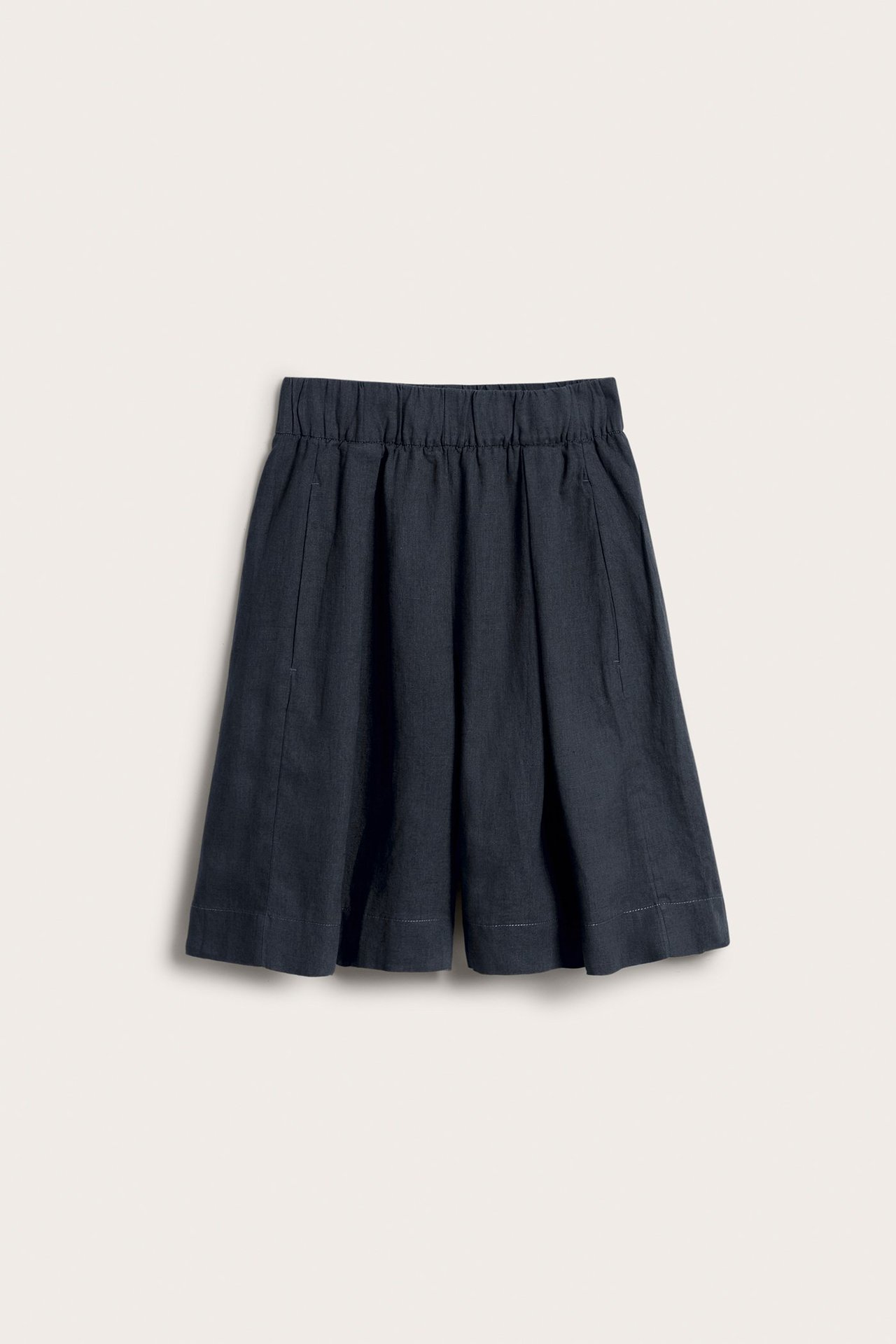 Edestä, tummansiniset polvipituiset pellavashortsit joustavalla vyötäröllä ja sivutaskuilla.