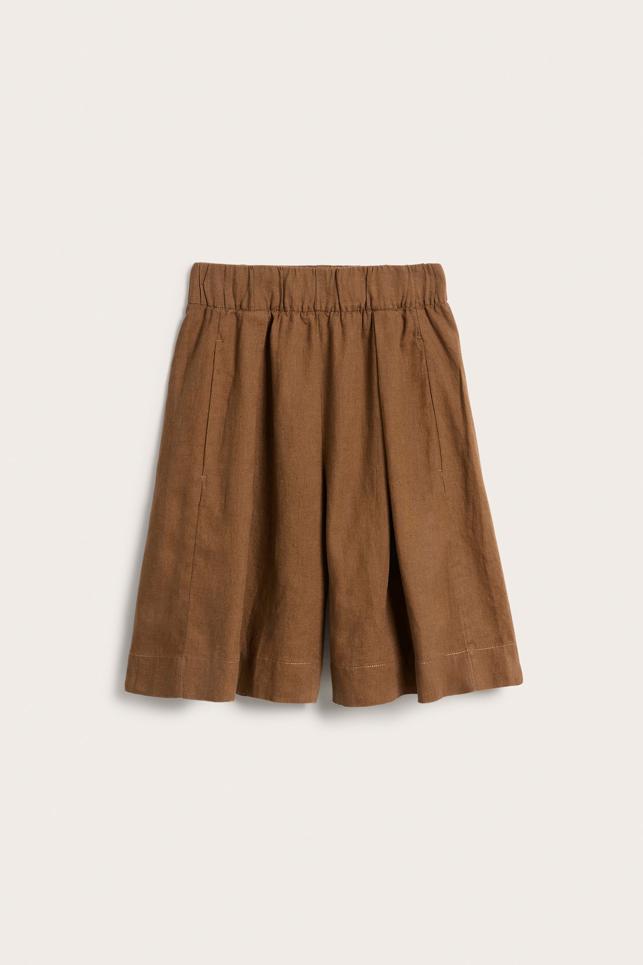 Frontvy av bruna knälånga linneshorts i bermudamodell med resår i midjan och sidfickor.