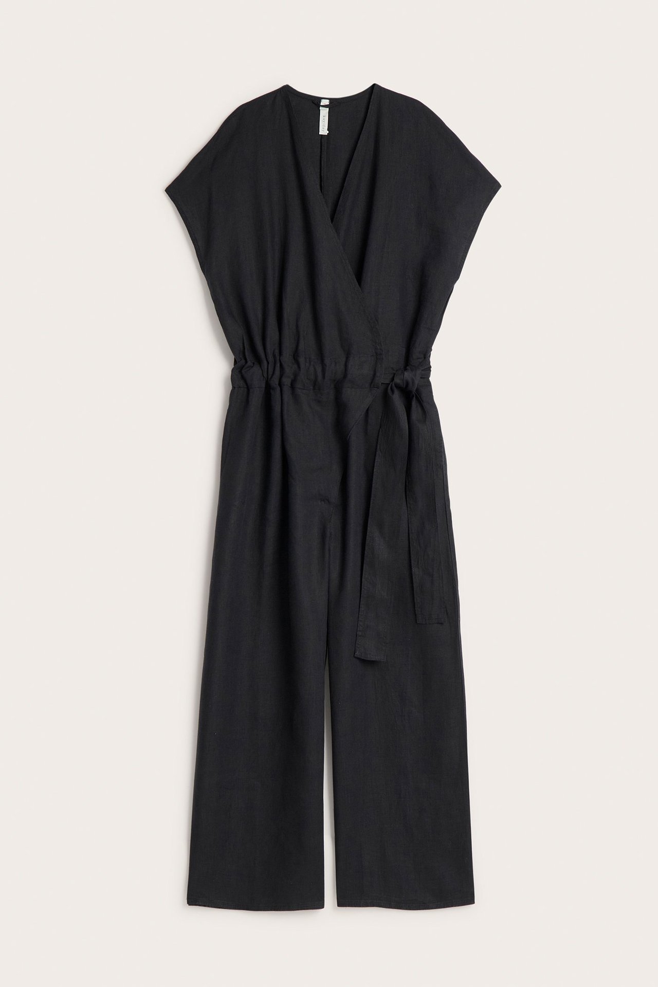 Edestä: musta pellavahaalari, jossa kietaisutoppi, joustovyötärö, solmimisvyö ja leveät lahkeet.