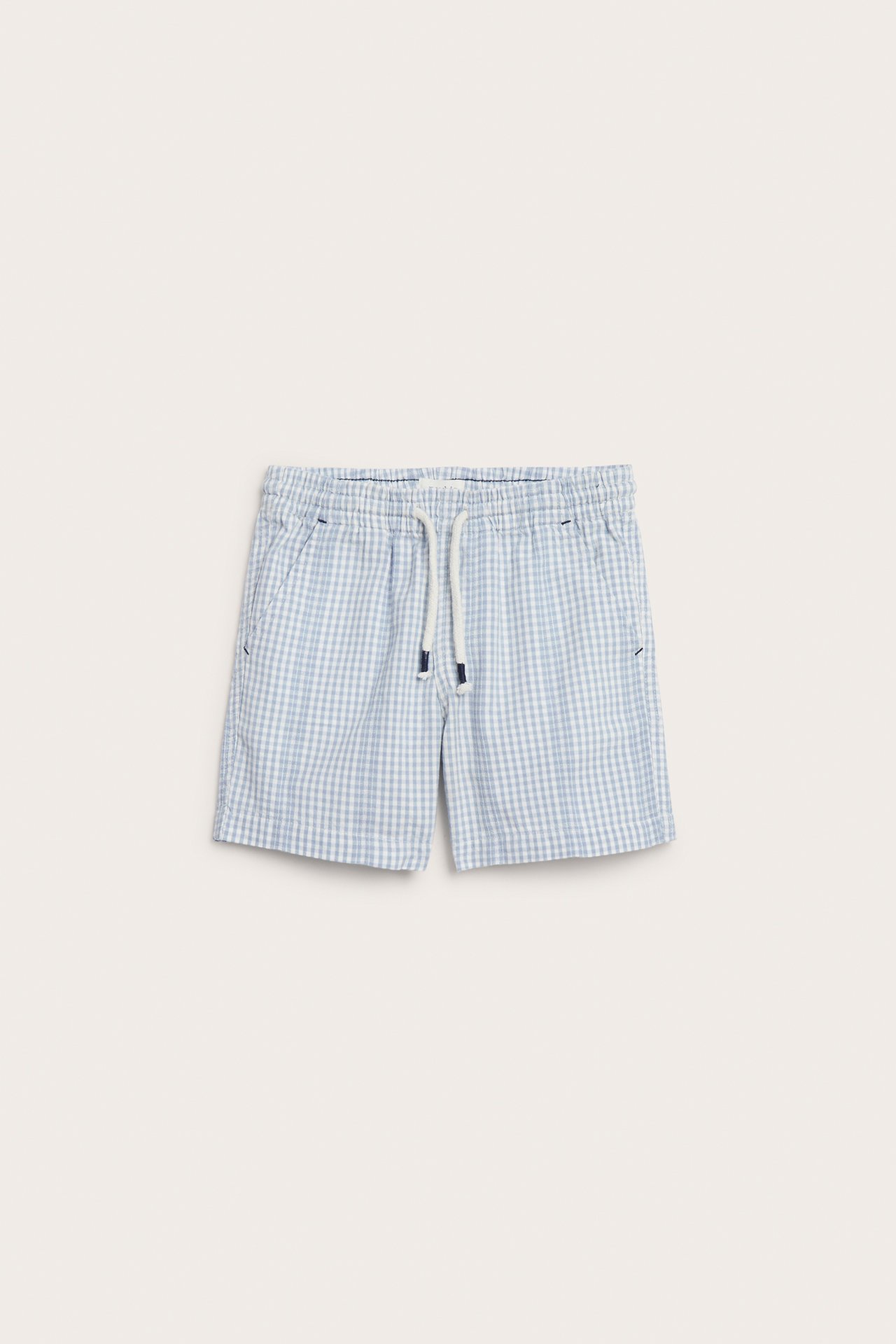 Forfra: Rutete shorts i lyseblå og offwhite bomull med snøring i midjen og sidelommer.