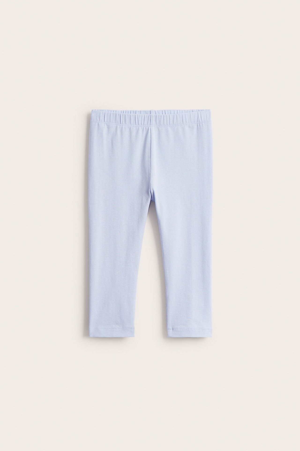 Widok z przodu jednolitych, liliowych legginsów dziecięcych 3/4 z mieszanki bawełny, z elastyczną talią.