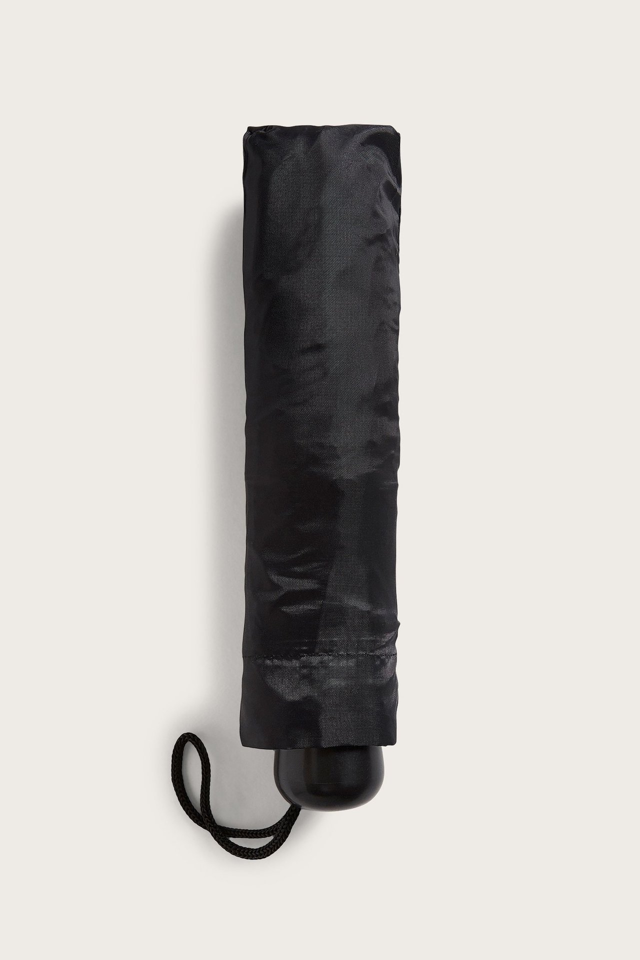 Svart paraply i teleskopmodell ihopfällbar, når 55cm, med metalldetaljer, sett från fronten.