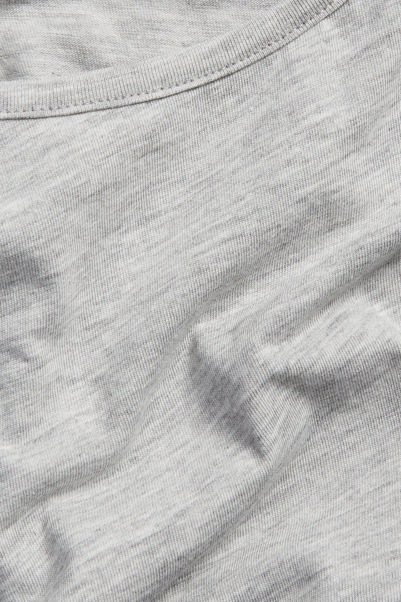 Närbild av en ljusgrå melerad t-shirt i bomullsblandning med ribbad rundhals.