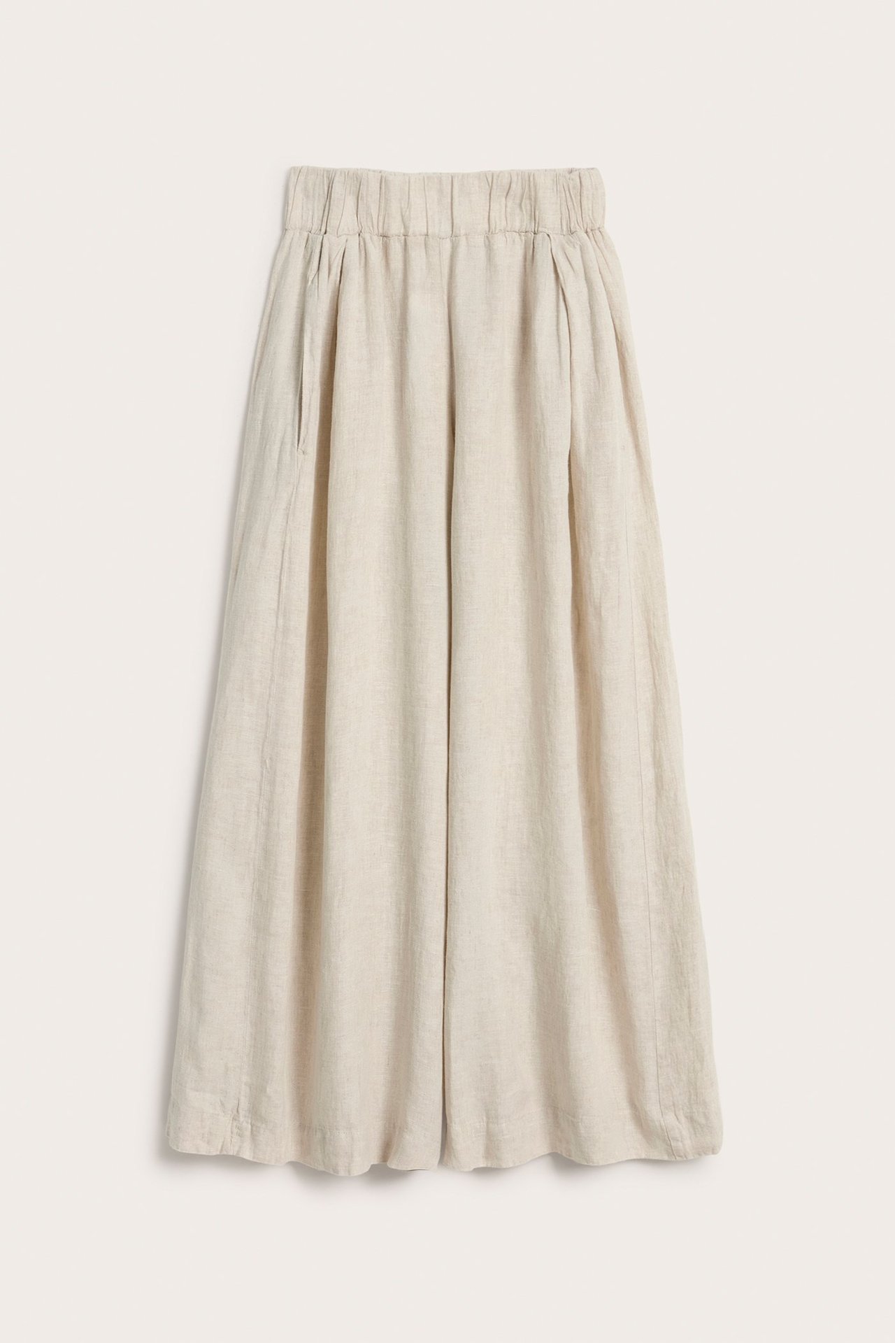 Edestä: beiget meleeratut pellavahousut leveillä lahkeilla, joustovyötäröllä, laskoksilla ja sivutaskuilla.