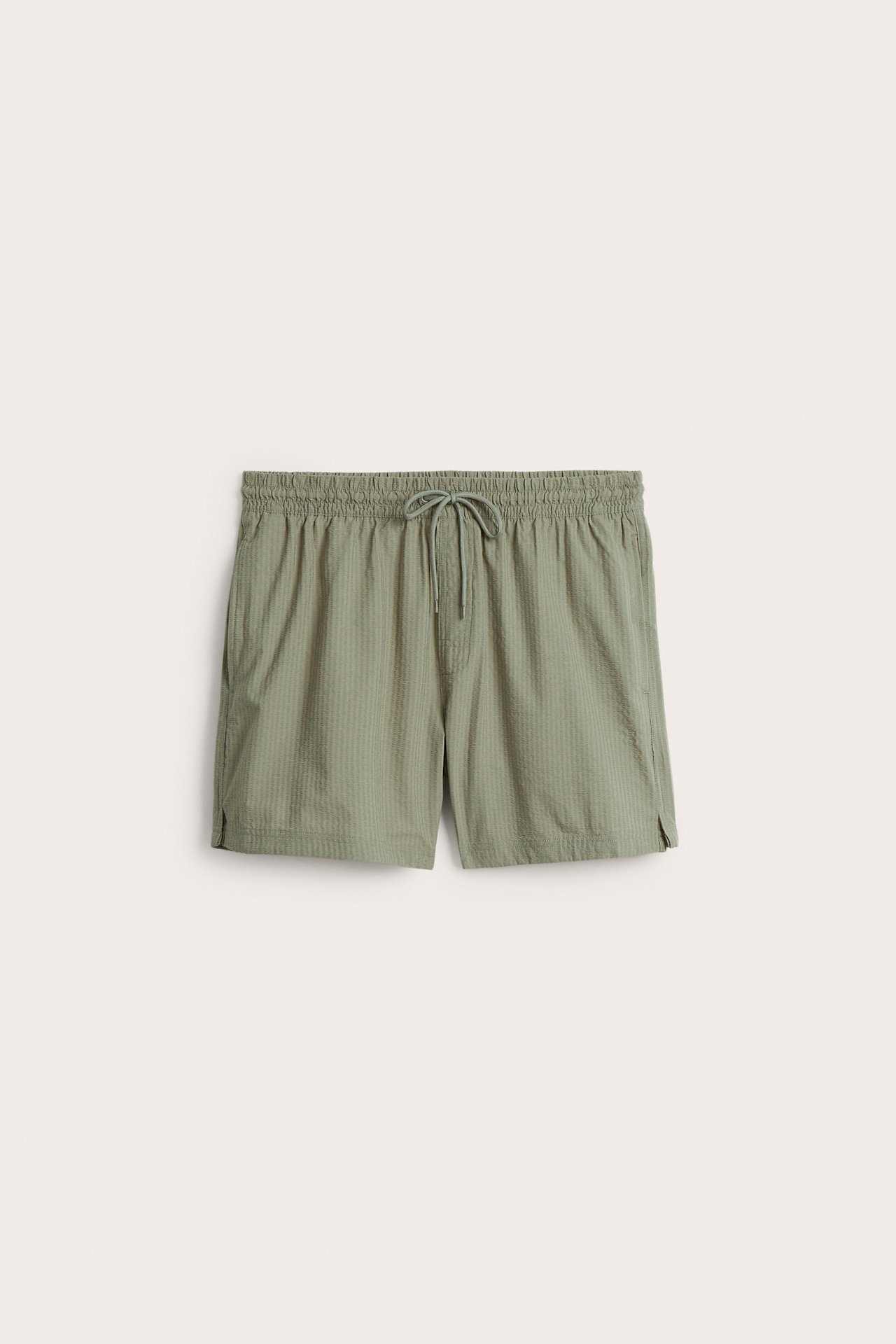 Framifrån: Herrbadshorts i grön seersucker med resår och dragsko i midjan samt sidfickor.