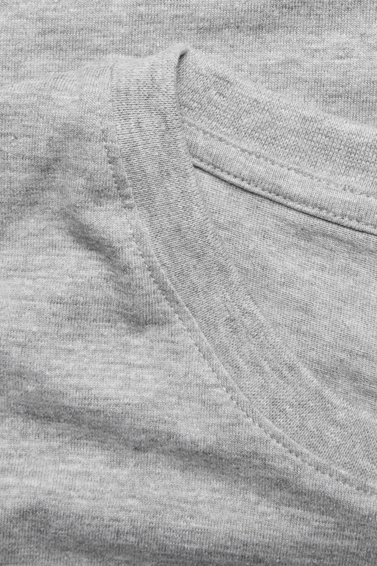 Zbliżenie męskiego szarego melanżowego t-shirtu z okrągłym dekoltem z mieszanki bawełny.