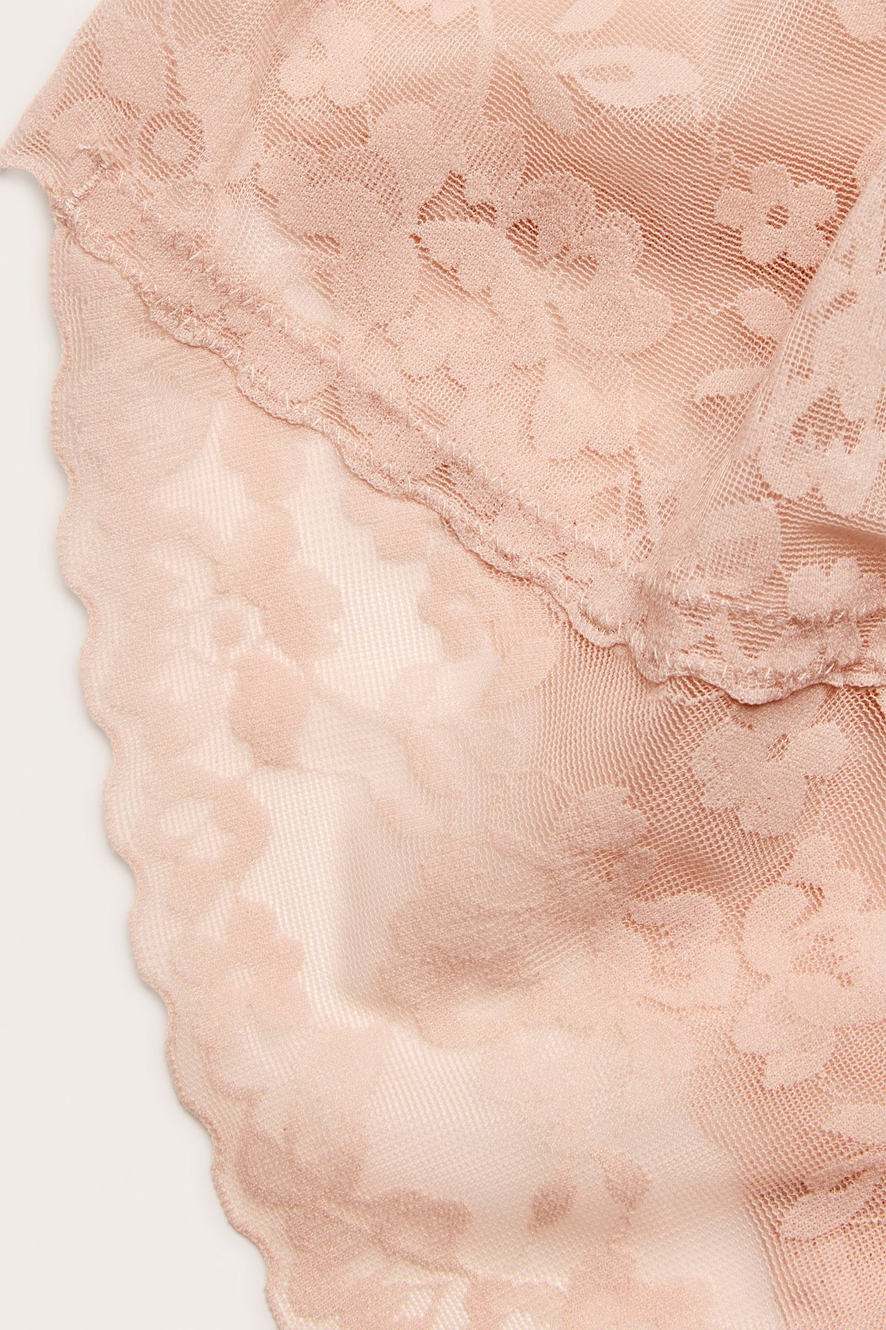 Zbliżenie na jasnoróżowe modelujące figi brazylijskie z koronkowym wzorem kwiatowym.