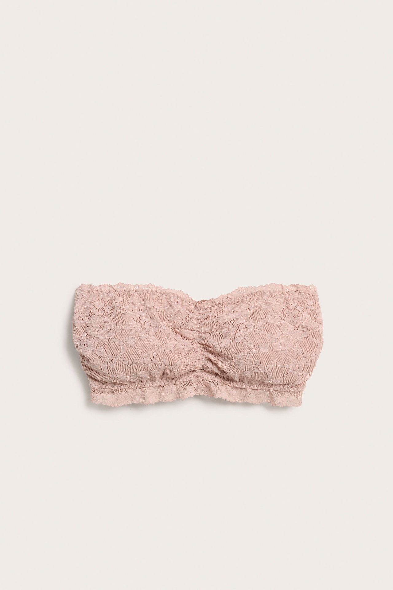 Widok z przodu jasnoróżowego koronkowego biustonosza bandeau z marszczeniem na środku.