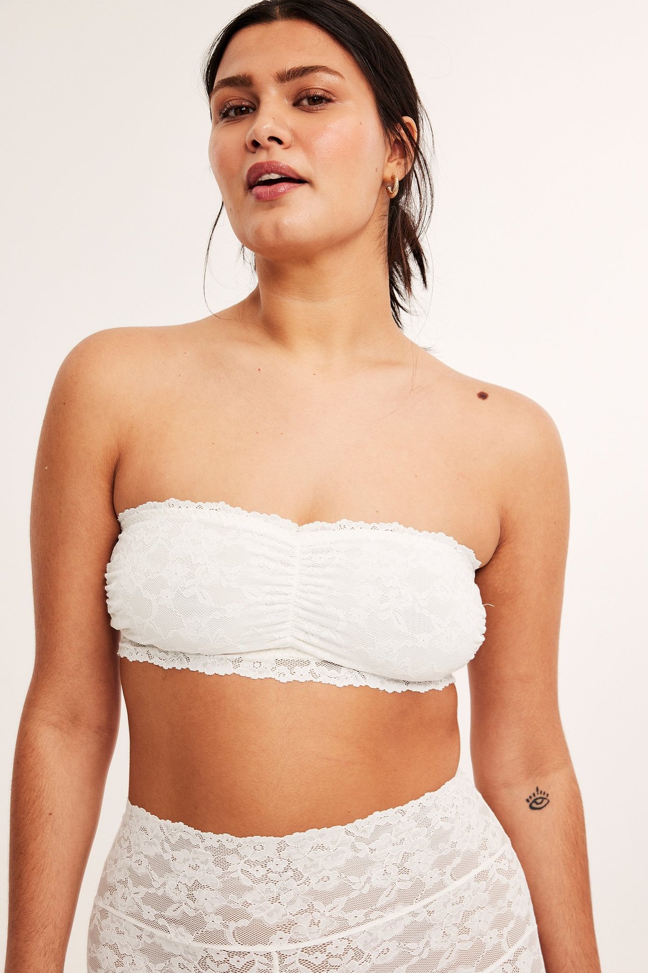 Widok z przodu: kobieta w ecru koronkowym biustonoszu bandeau z marszczeniem i pasujących koronkowych majtkach.