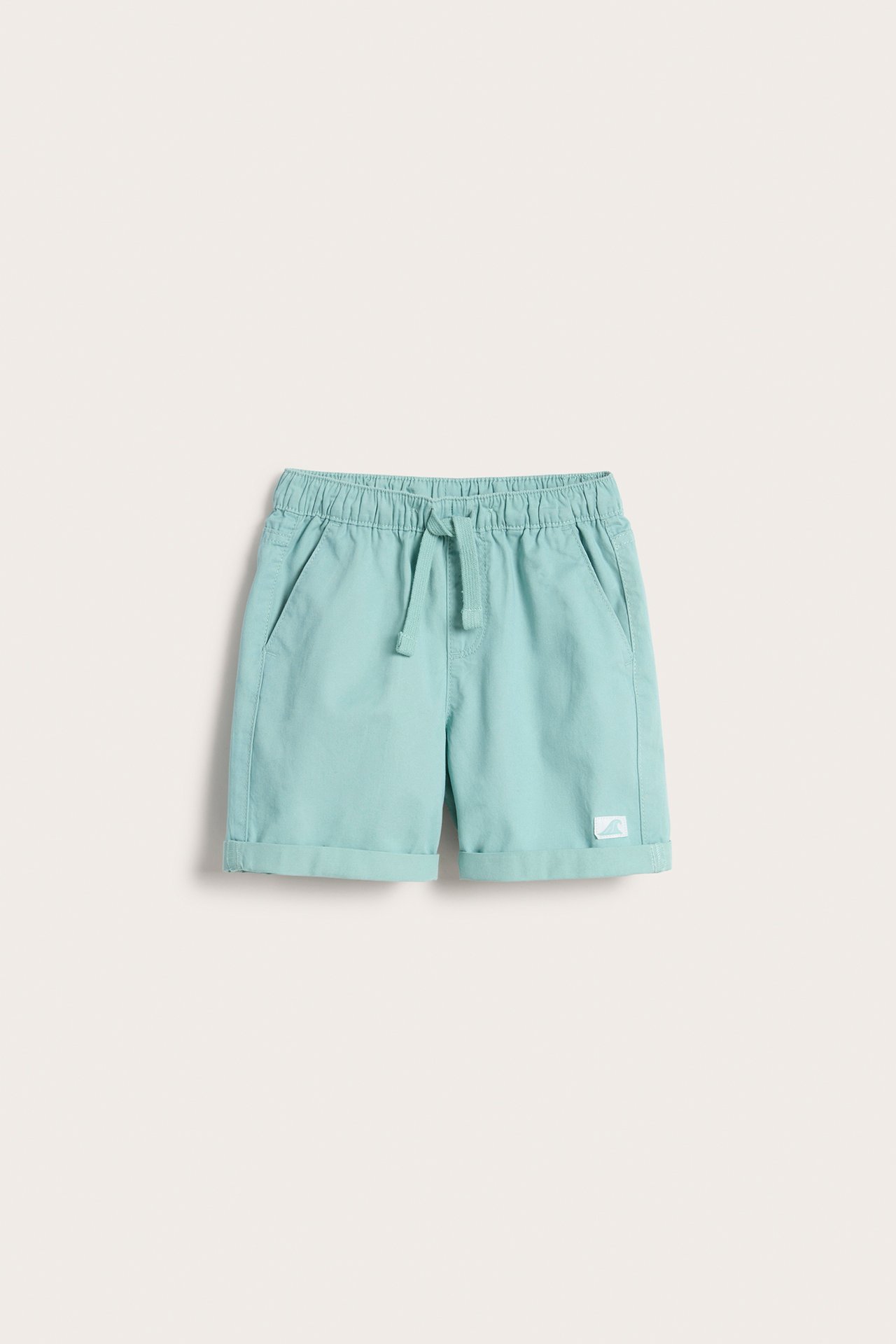 Frontvisning av lysegrønne bomullsshorts for barn med elastisk snøring i midjen og oppbrettede benkanter.