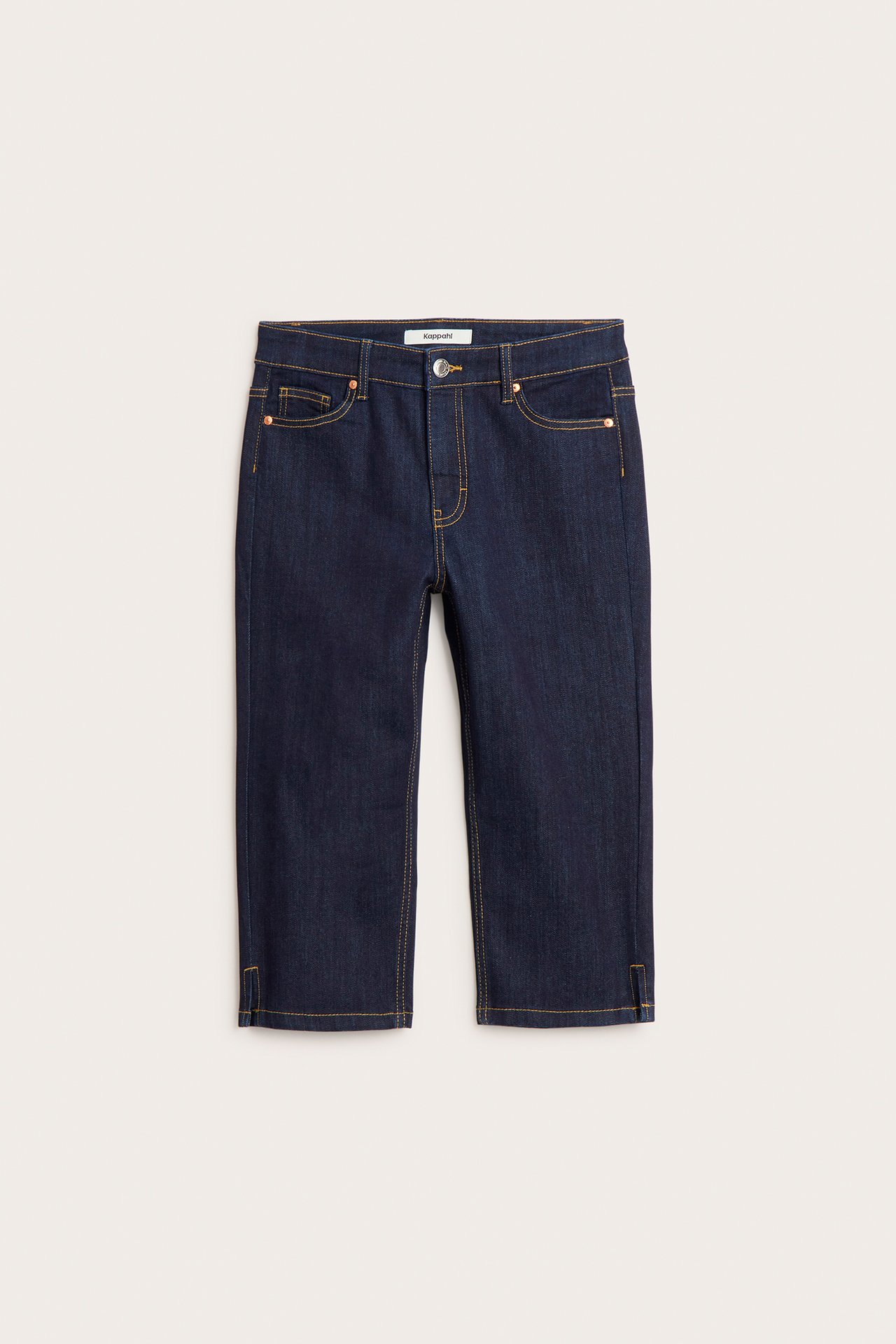 Edestä tummat denim capri-farkut keltaisilla tikkauksilla, napilla, vetoketjulla, taskuilla ja pienillä halkioilla.