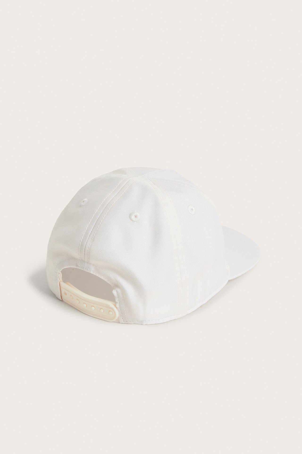 Takakuva vaaleanbeigestä lasten lippiksestä säädettävällä snapback-kiinnityksellä.