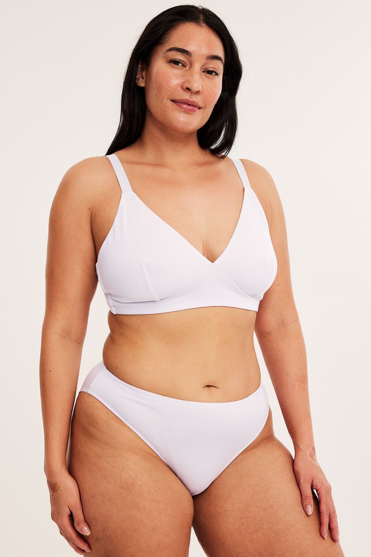 Frontbilde av en kvinne i lys rosa lyocell brazilian truse og matchende myk BH.