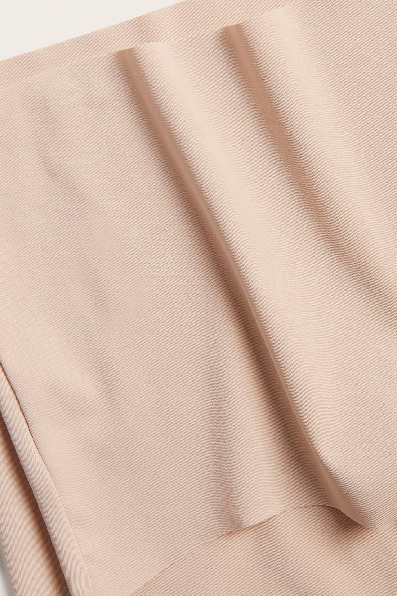 Zbliżenie jasnoróżowych, bezszwowych fig typu hipster z gładkiej mikrofibry.