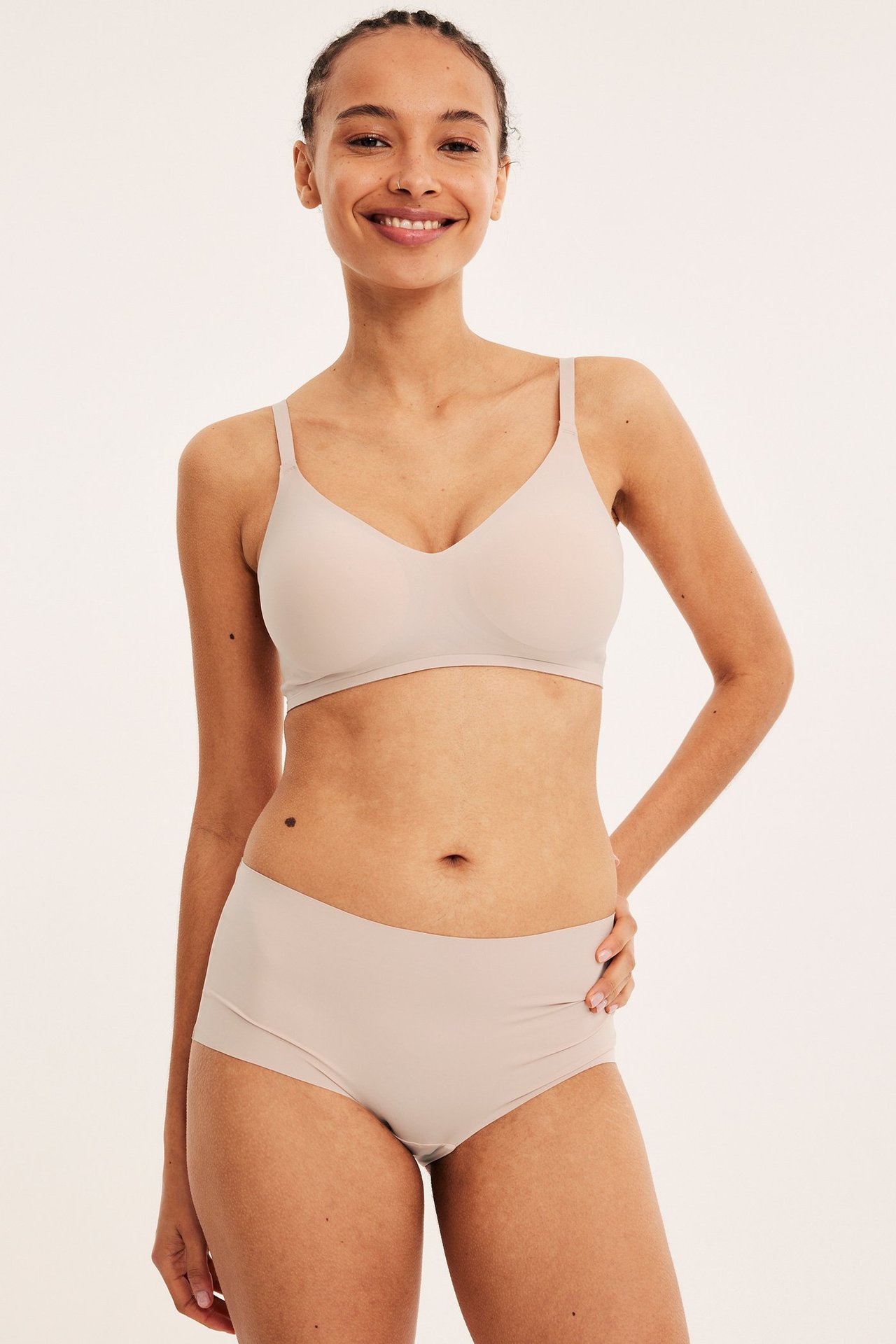 Forfra, kvinne i lys rosa cleancut hipster truse og matchende BH.