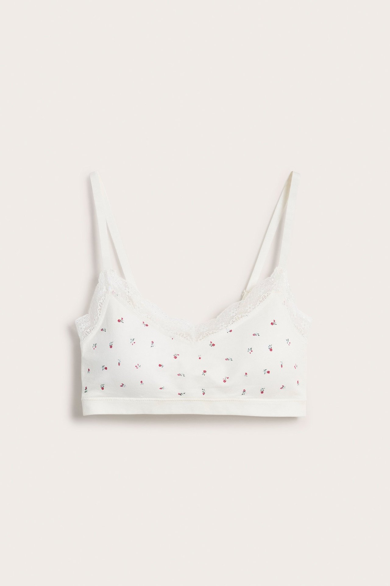 Edestä: valkoinen saumaton bralette pienellä punaisella kukkakuviolla ja pitsireunuksella.