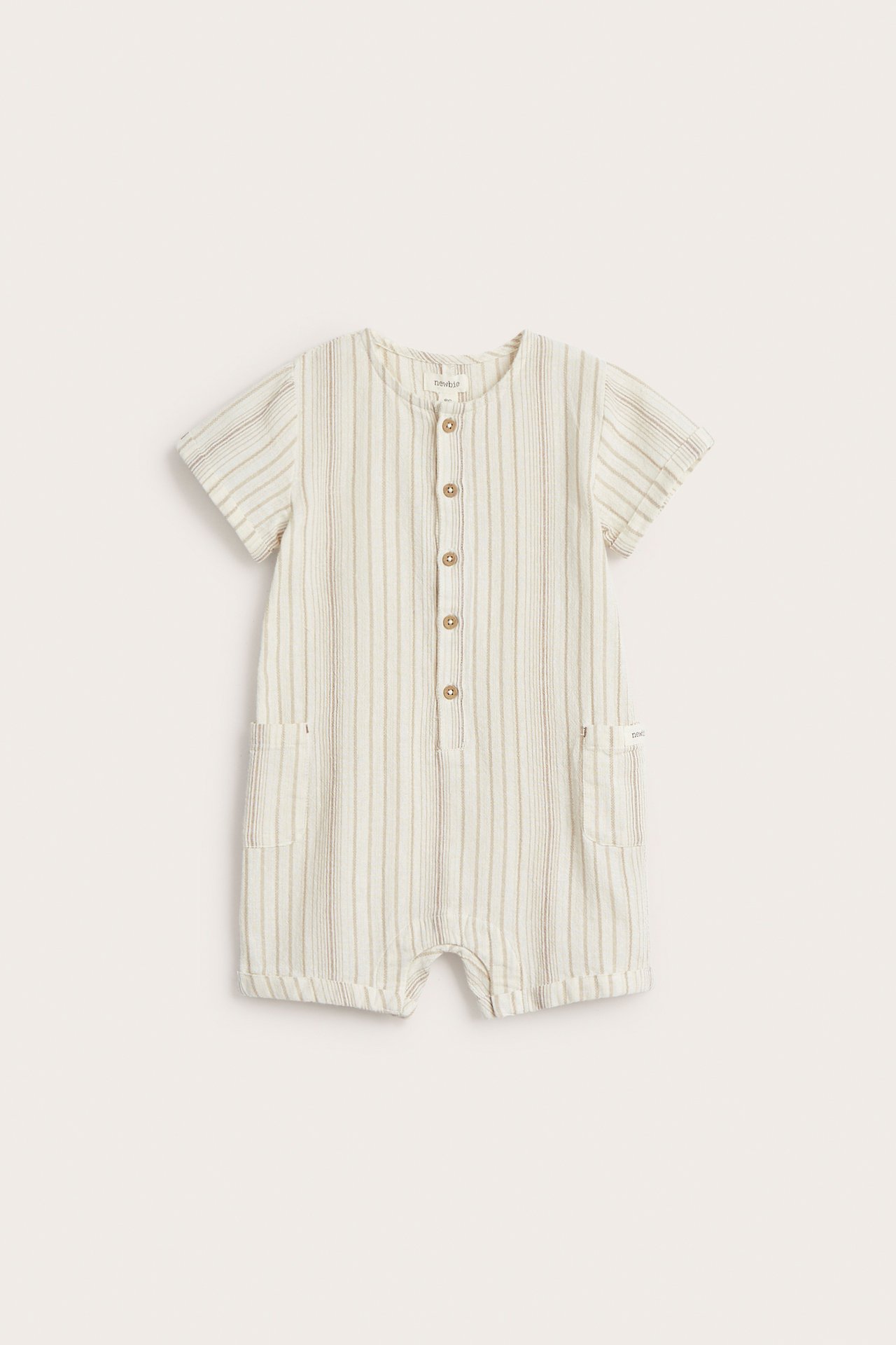 Edestä: Luonnonvalkoinen raidallinen vauvan playsuit lyhyillä hihoilla, napeilla ja kahdella taskulla.