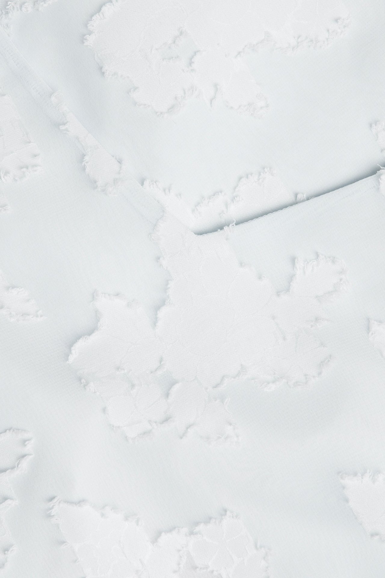 Zbliżenie na jasnoniebieską krótką sukienkę z żakardowym wzorem.