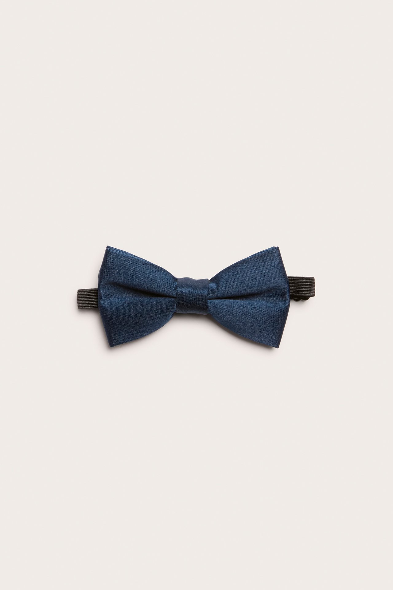 Framifrån, en mörkblå enfärgad fluga i polyester med svart resårband.