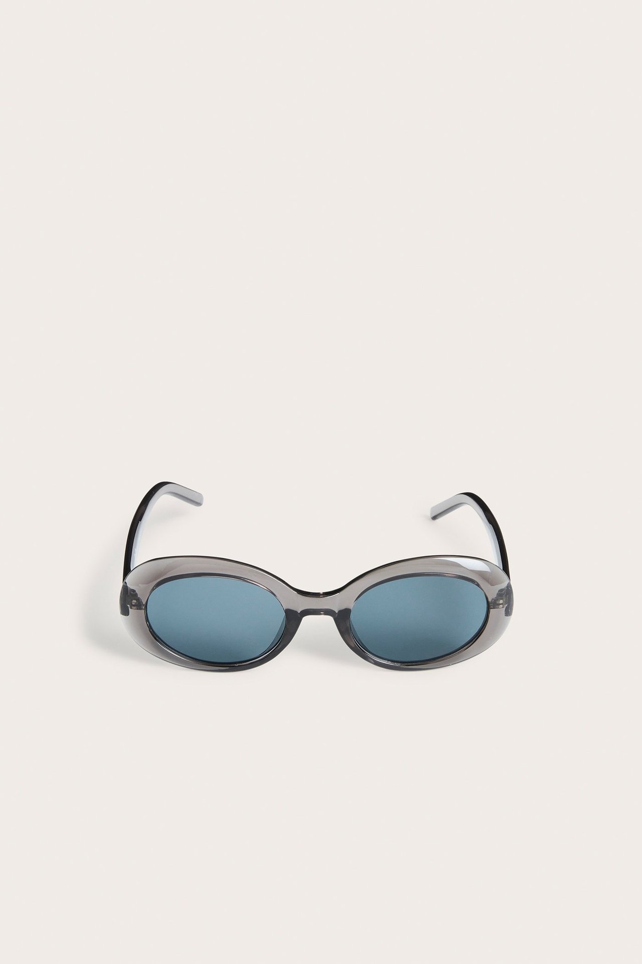 Widok z przodu ciemnoszarych owalnych okularów przeciwsłonecznych z tworzywa z niebieskimi soczewkami.