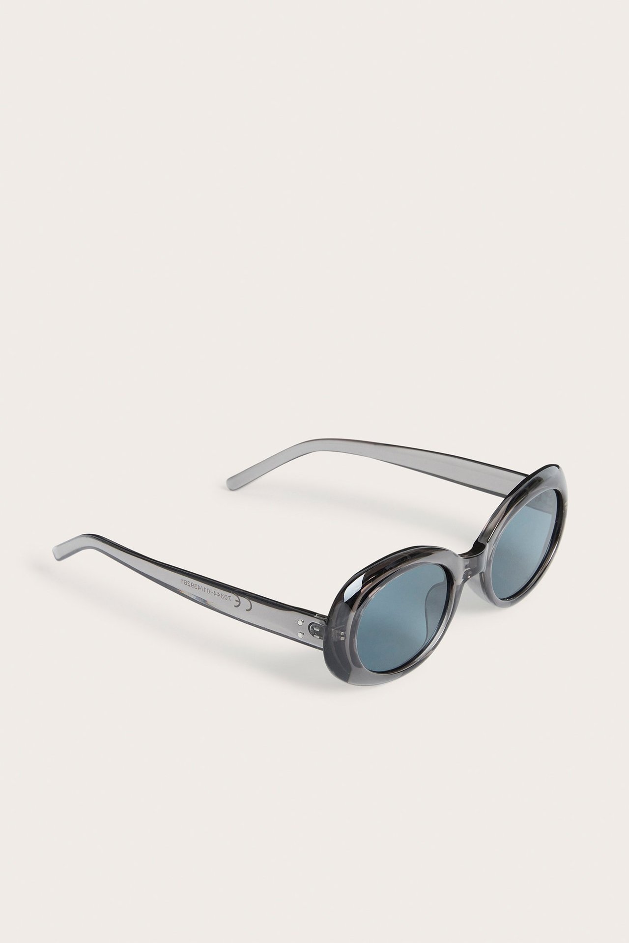 Skośny widok ciemnoszarych plastikowych okularów przeciwsłonecznych z owalnymi soczewkami.