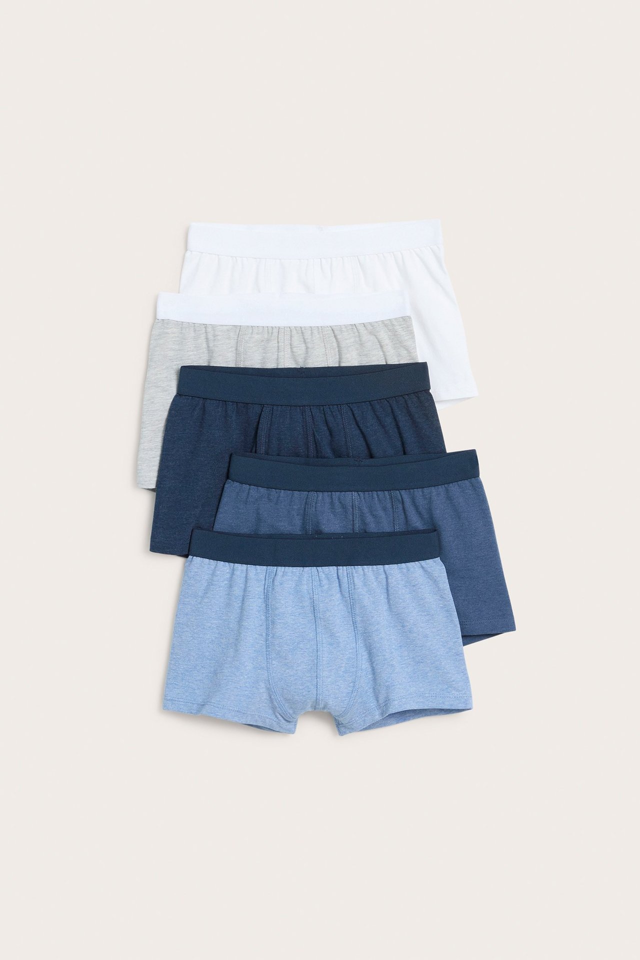 Widok z przodu pięciu ułożonych bokserek dziecięcych melanżowych: jasnoniebieskie, średnioniebieskie, granatowe, szare i białe.