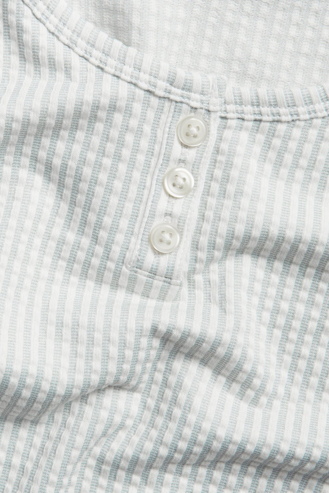 Zbliżenie przód: jasnozielono-biała piżama w paski z dżerseju seersucker z listwą na trzy guziki.