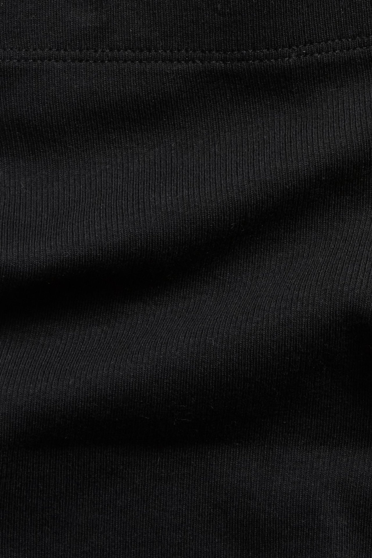 Zbliżenie na czarne prążkowane szorty kolarskie, przedstawiające teksturowany materiał z mieszanki bawełny.