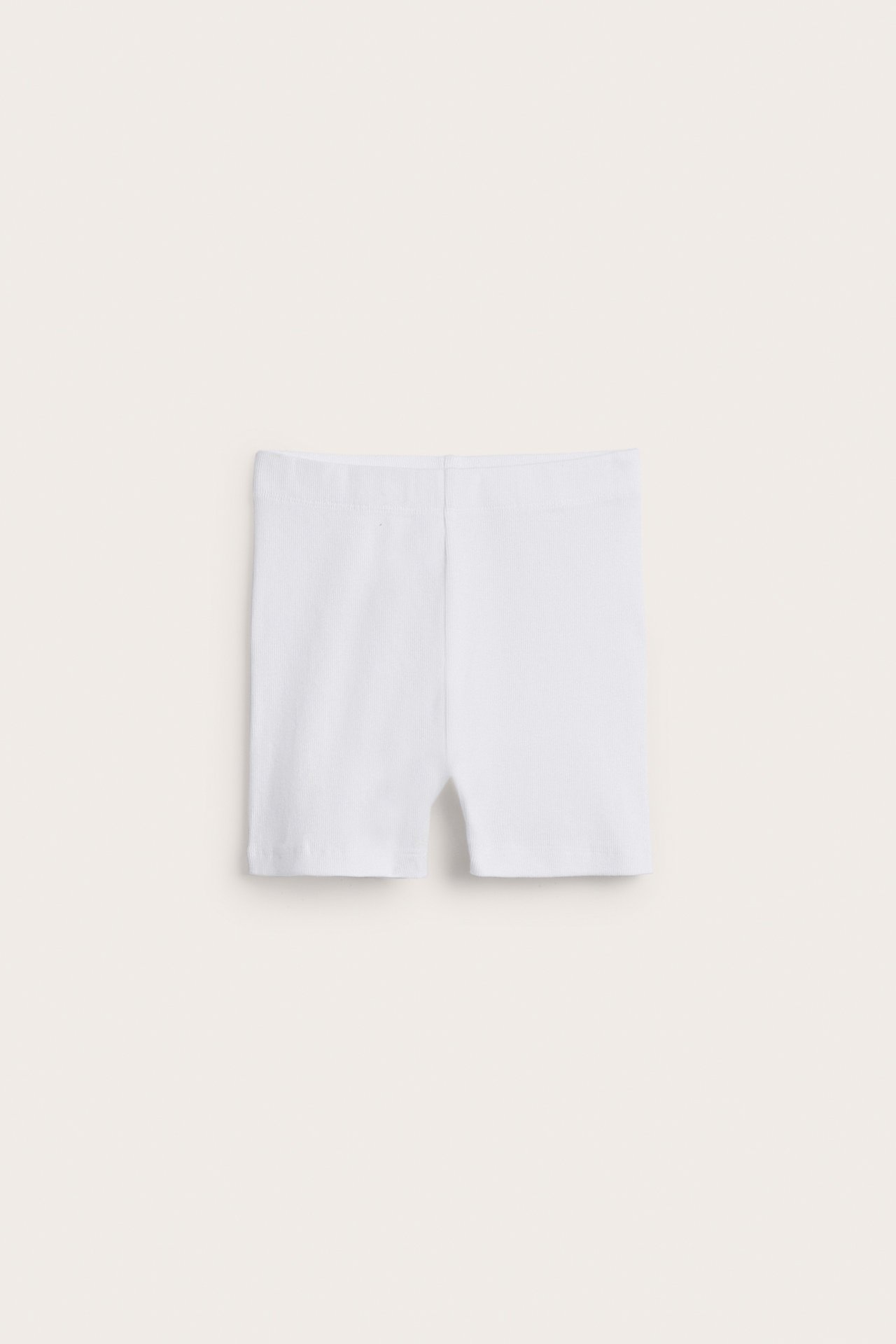 Forfra, hvite ribbestrikkede sykkelshorts i bomull og elastan.