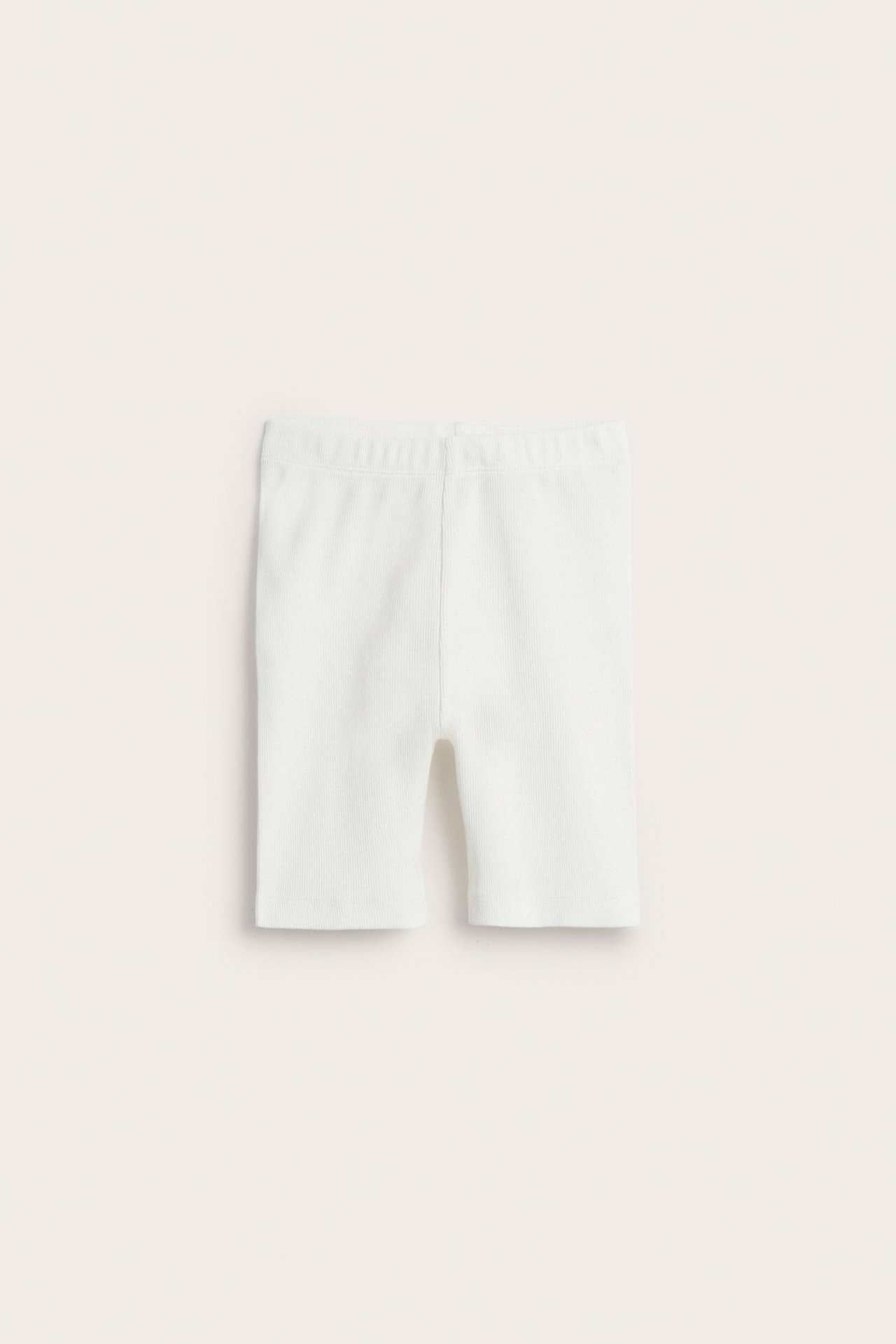 Edestä, valkoiset ribatut lasten pyöräilyshortsit puuvillasekoitetta.