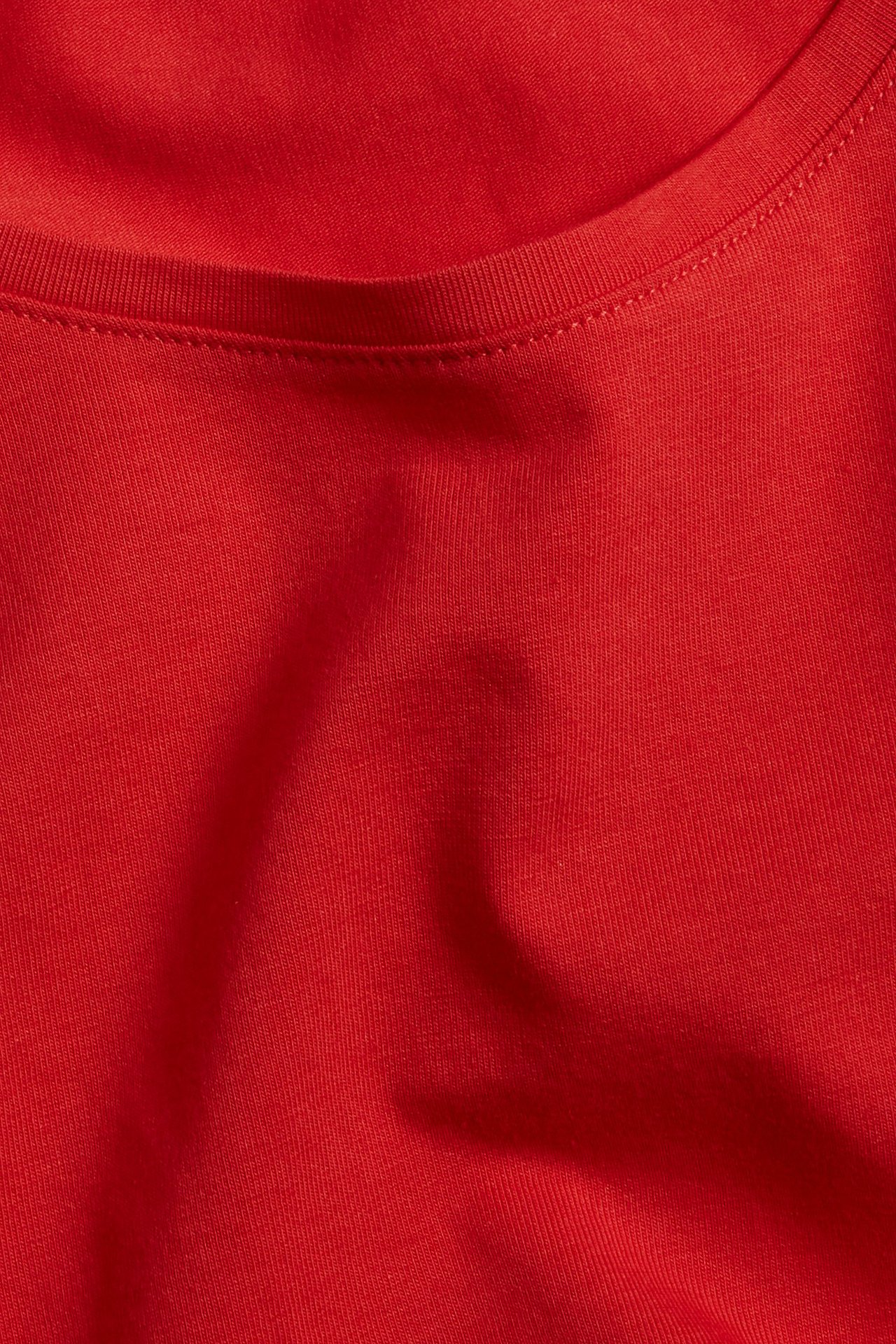 Zbliżenie czerwonej, bawełnianej koszulki z krótkim rękawem i dekoltem w łódkę.