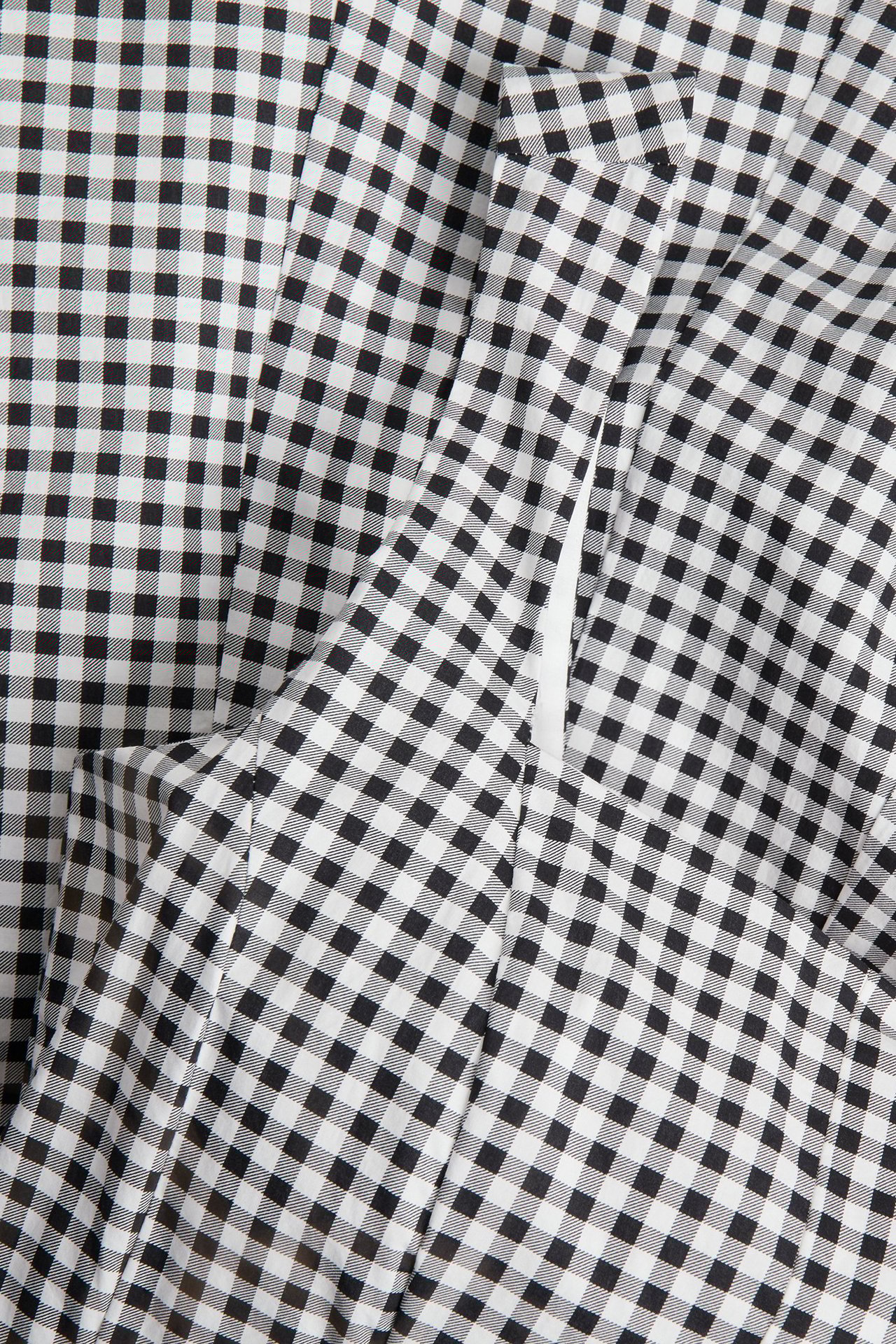 Zbliżenie czarno-białej sukienki z popeliny w kratkę, z boczną kieszenią i zamkiem.