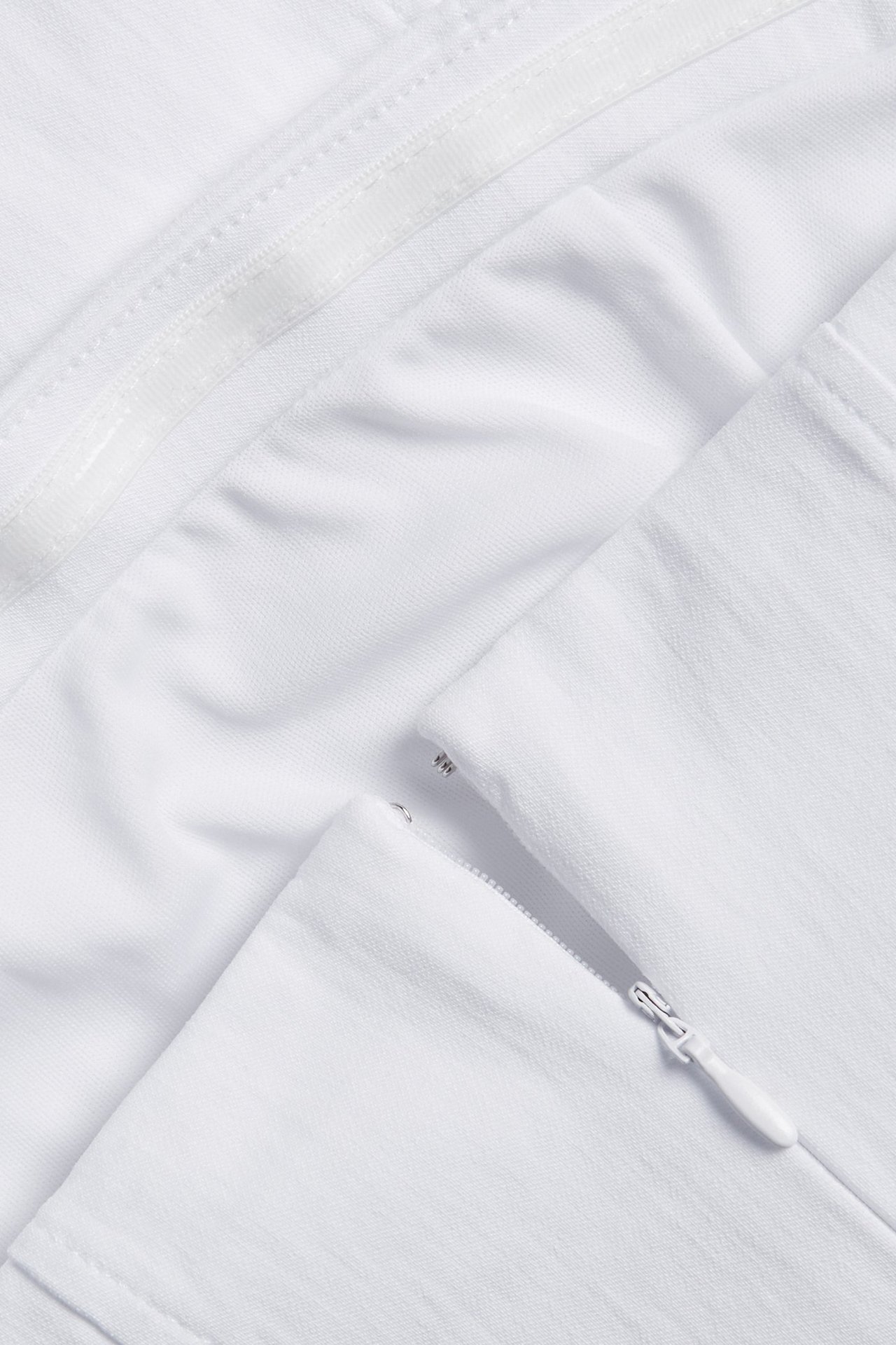 Zbliżenie białego bustieru, ukazujące biały zamek błyskawiczny z tyłu.