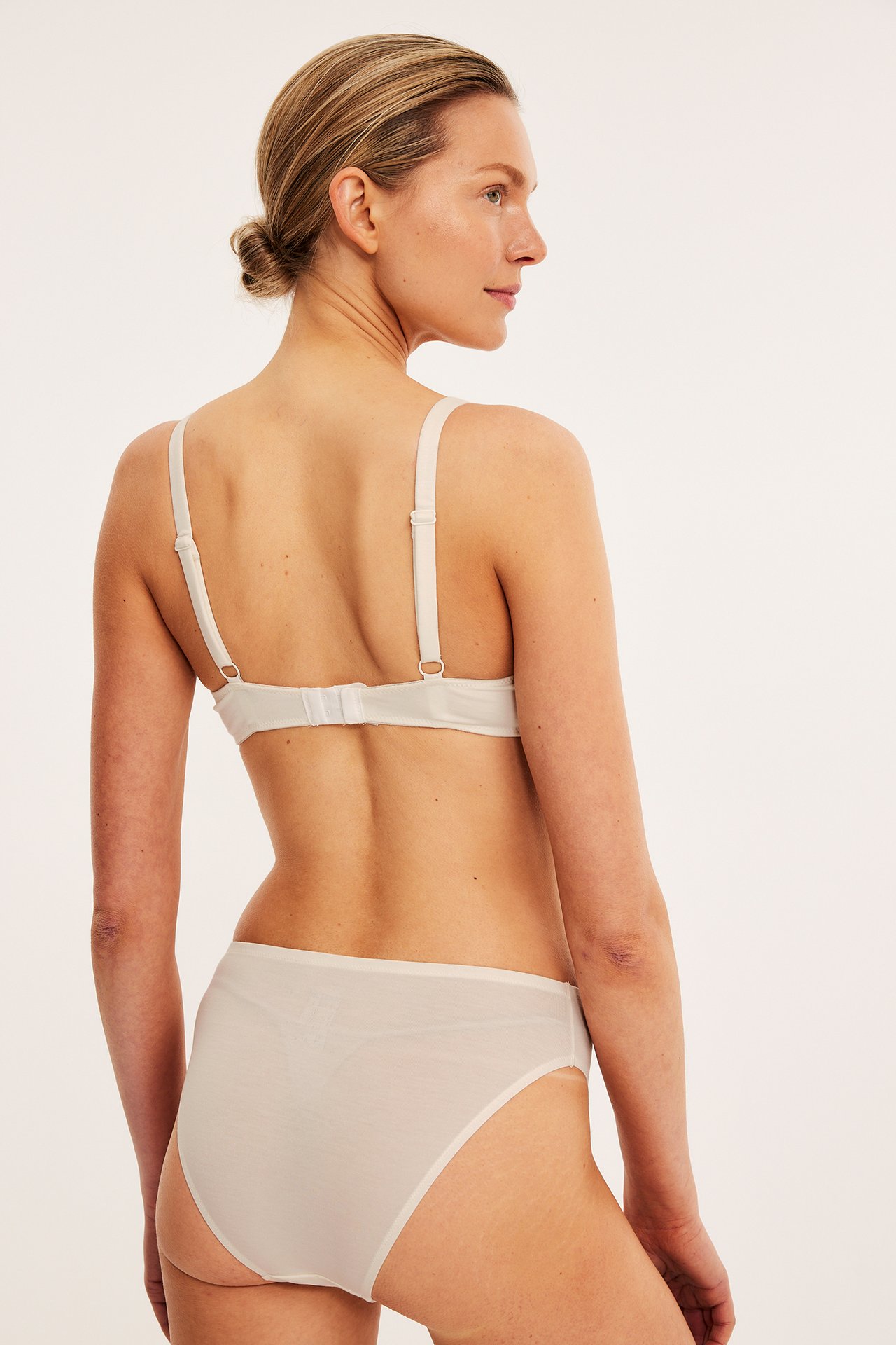 Bakfra: kvinne i hvit lyocell bralette med justerbare stropper og matchende truser.