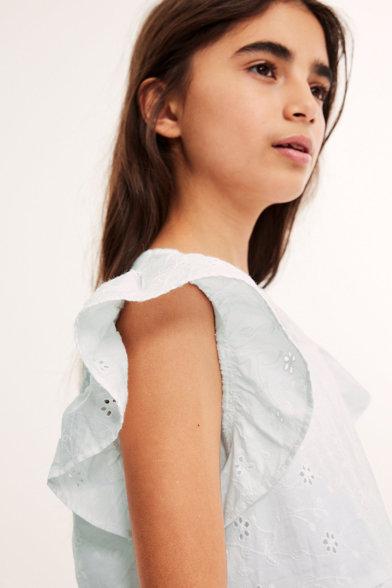 Vit barnblus i broderad bomull med peplum och broderie anglaise, frontvy.