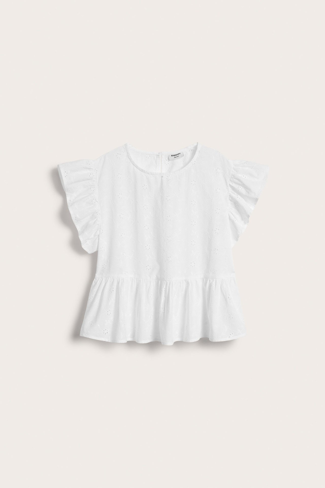 Framifrån, vit peplumblus i bomull för barn med broderie anglaise och volangärmar.