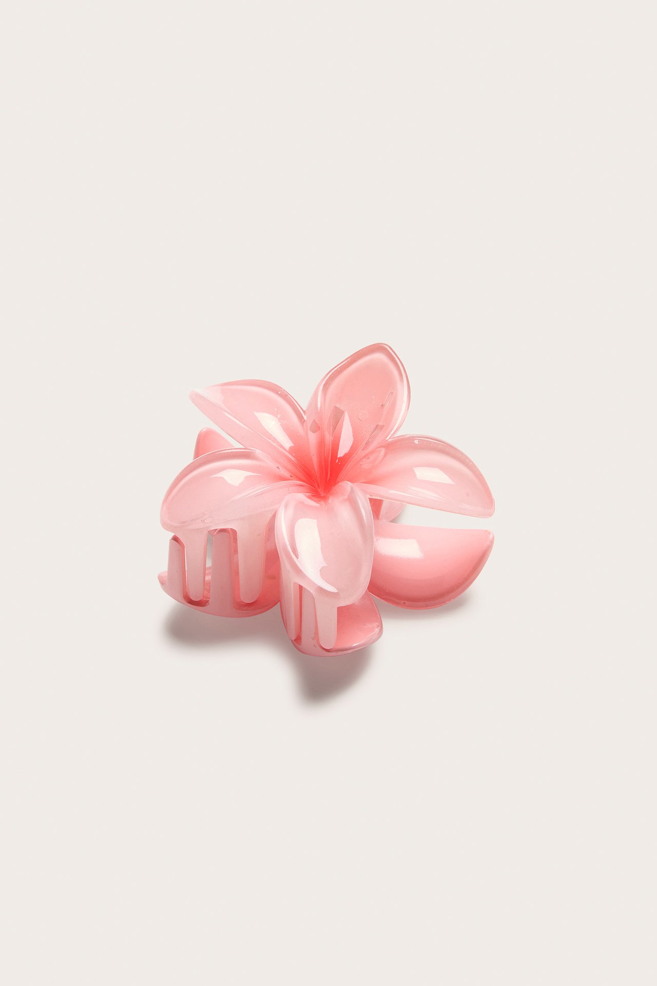 Nærbilde av en lys rosa blomsterhårklemme i plast.