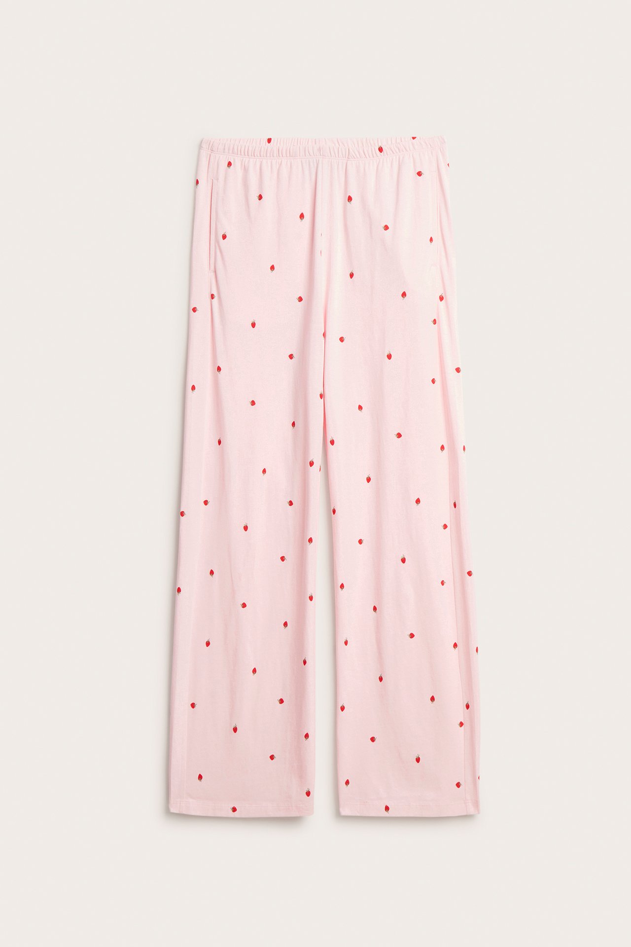 Frontvisning av rosa bomullsjersey pyjamasbukser med rødt jordbærmønster, vide ben og elastisk midje.