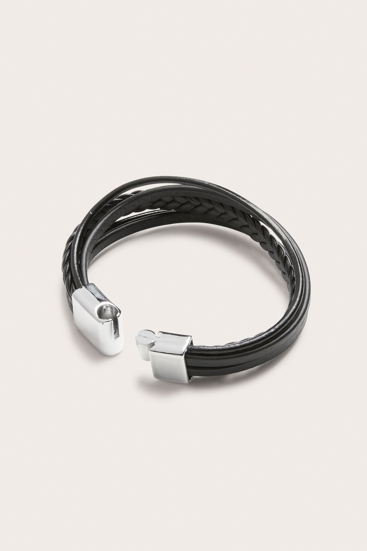 Zbliżenie na czarną wielopasmową bransoletkę PU dla chłopca, plecioną i gładką, ze srebrnym zapięciem.