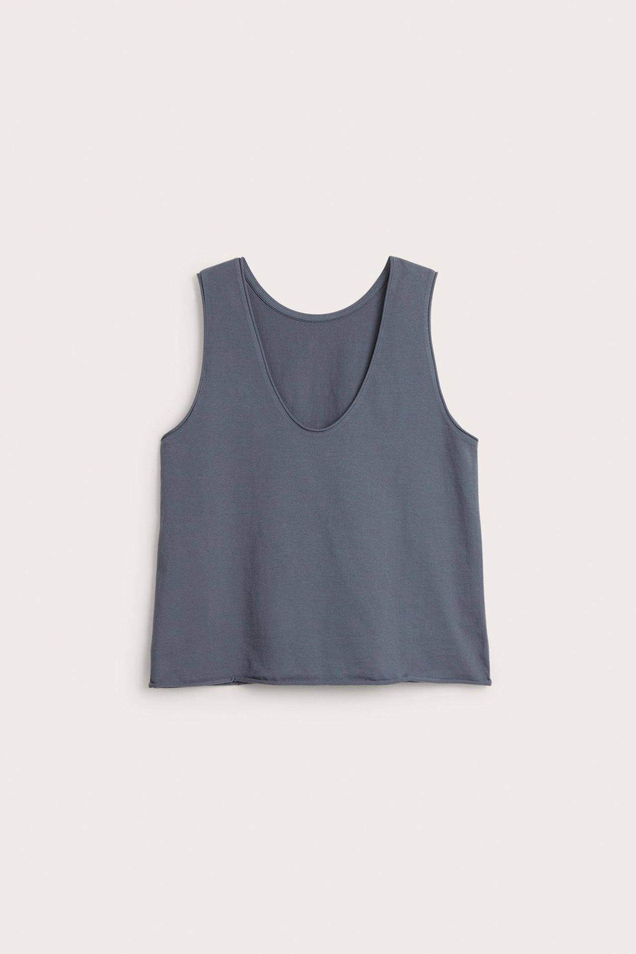 Frontvisning av en mørkeblå V-hals singlet i bomullsjersey med rå kant.