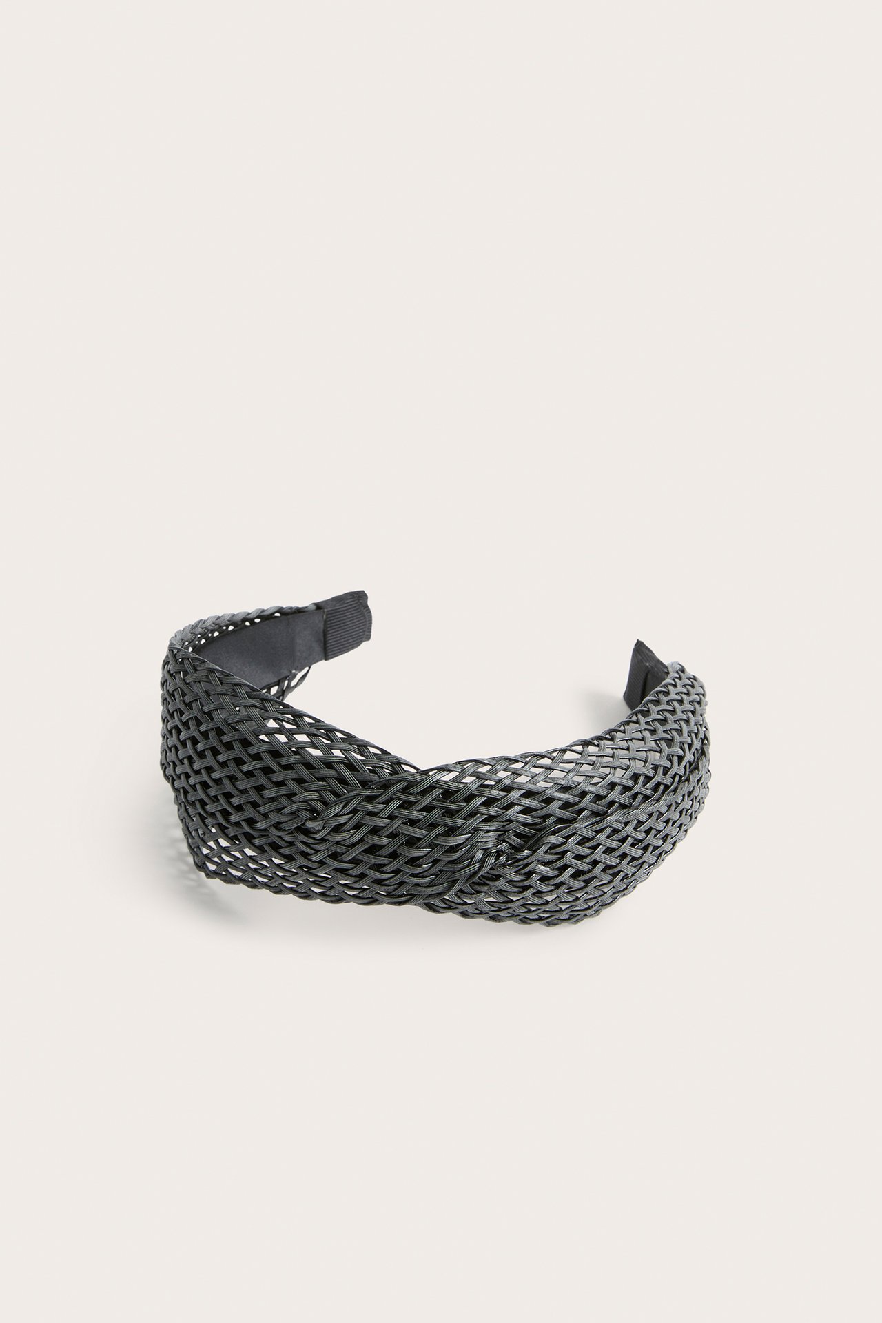 Framifrån, brett svart flätat diadem med tvinnad detalj.