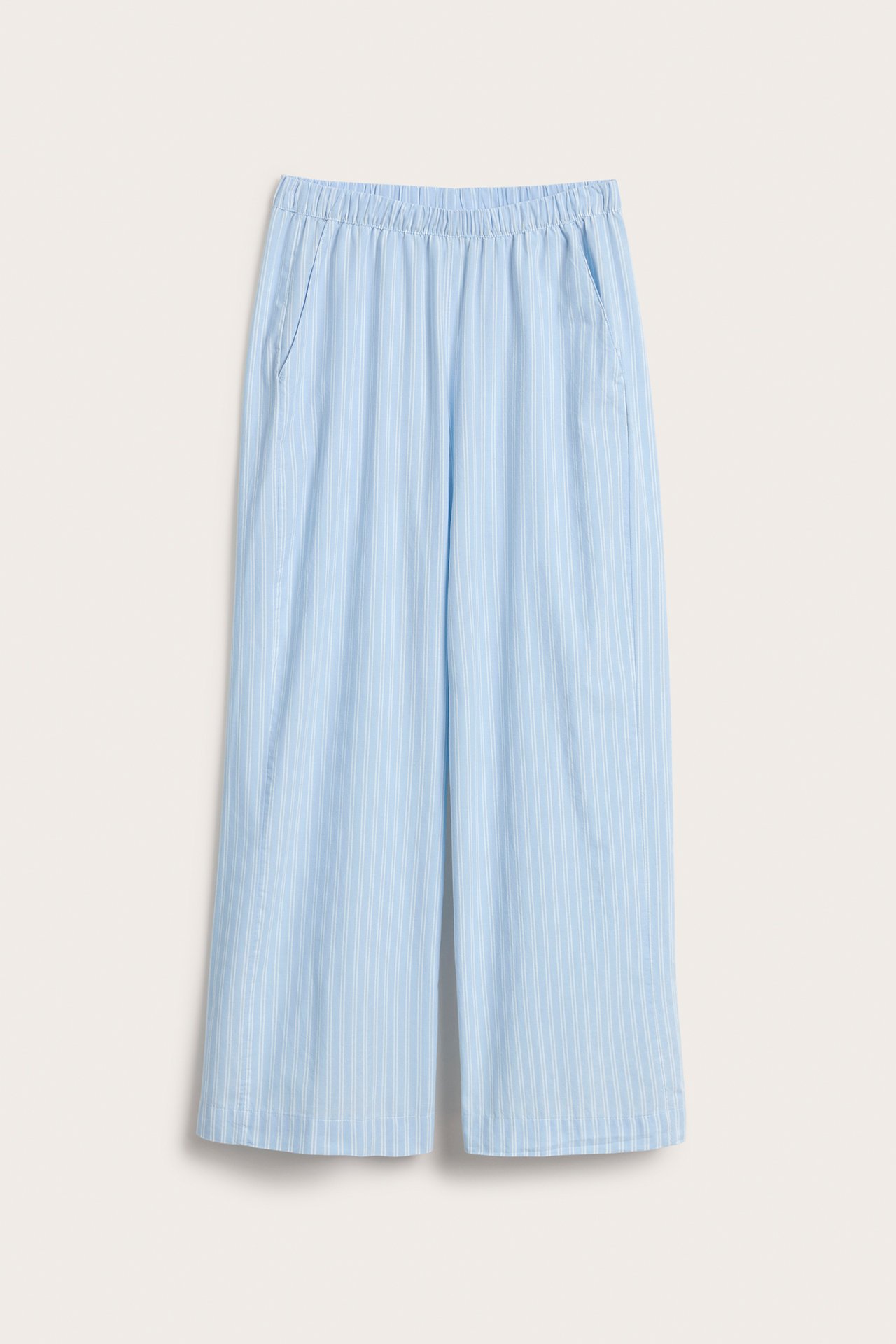 Frontvy av ljusblå randiga pyjamasbyxor i vävd bomull med resår i midjan och sidfickor.