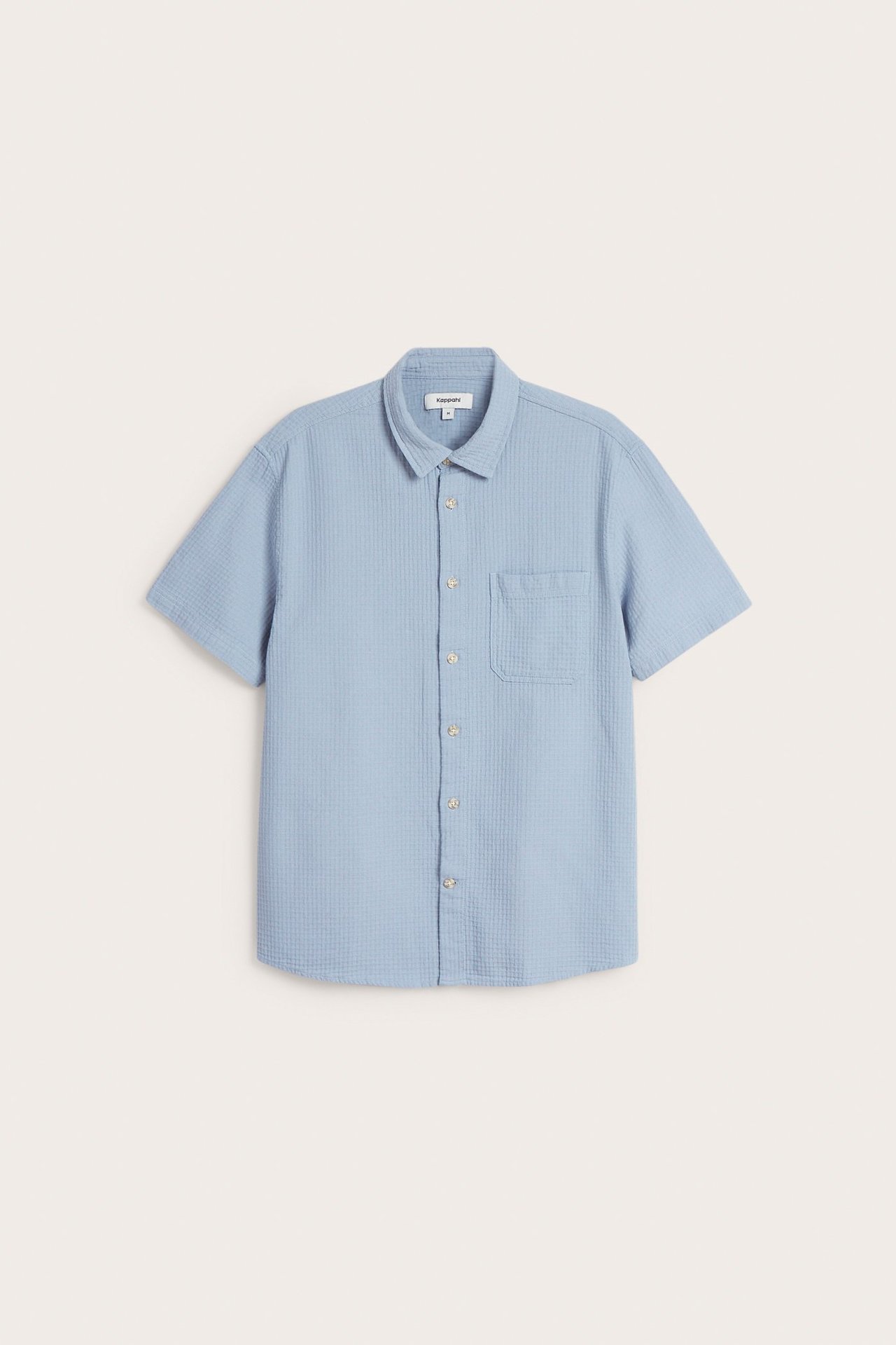 Edestä näkymä vaaleansinisestä miesten lyhythihaisesta puuvillapaidasta, jossa on kaulus ja rintatasku.