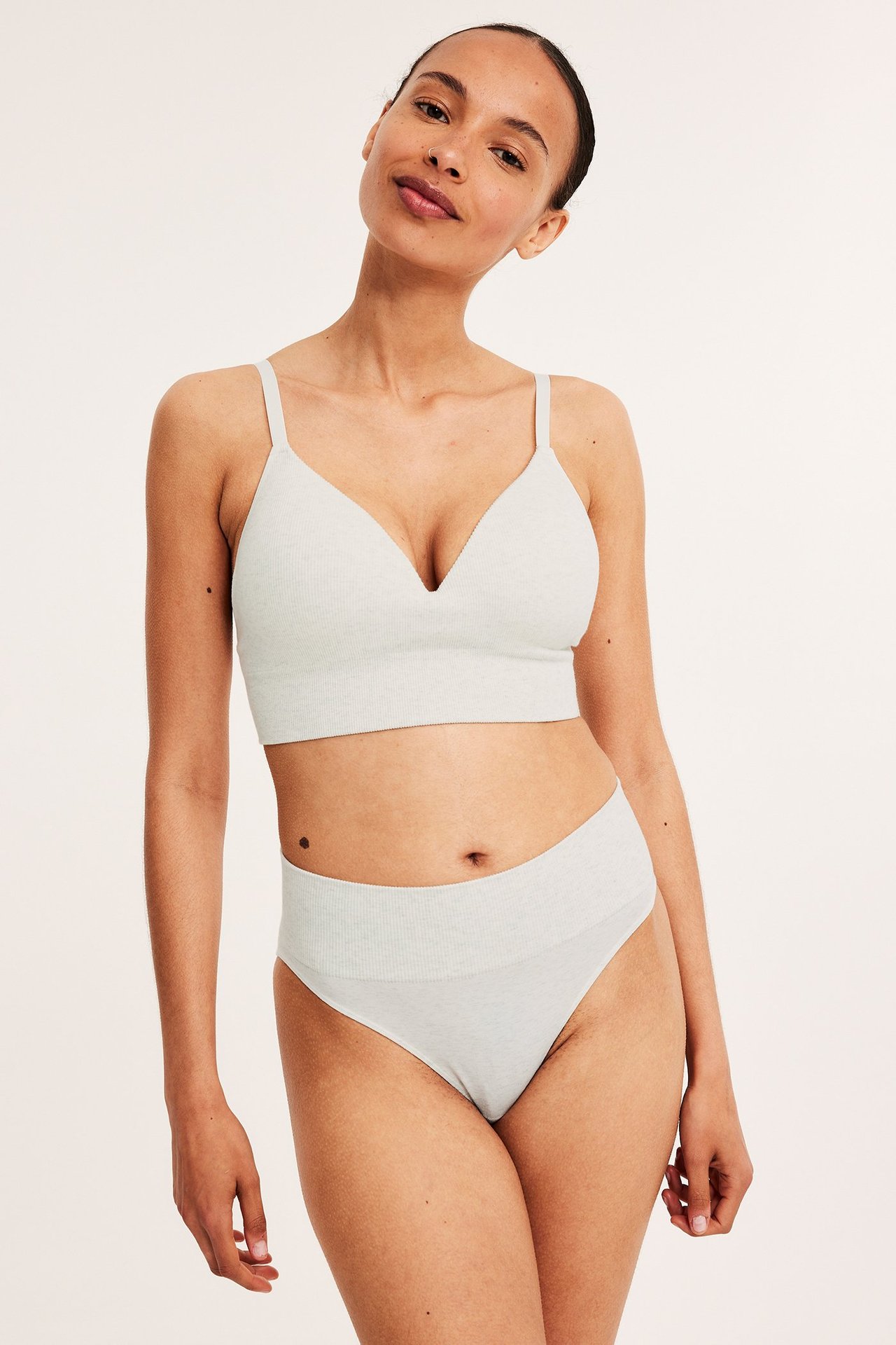 Forfra, kvinne i lys melert hvit sømløs brazilian truse med ribbet midje og matchende bralette.