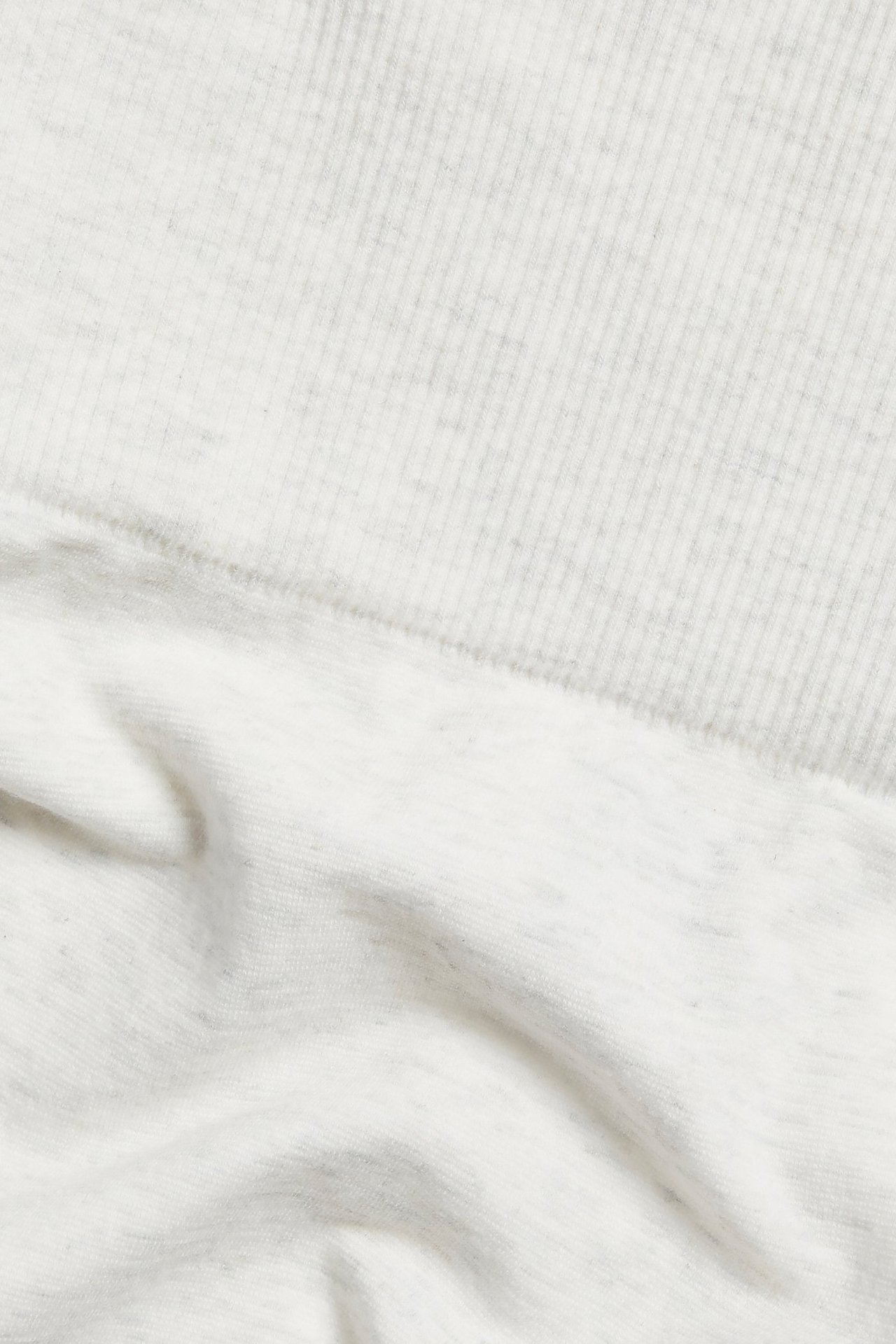 Zbliżenie na białe melanżowe szorty z mieszanki bawełny z prążkowanym pasem.