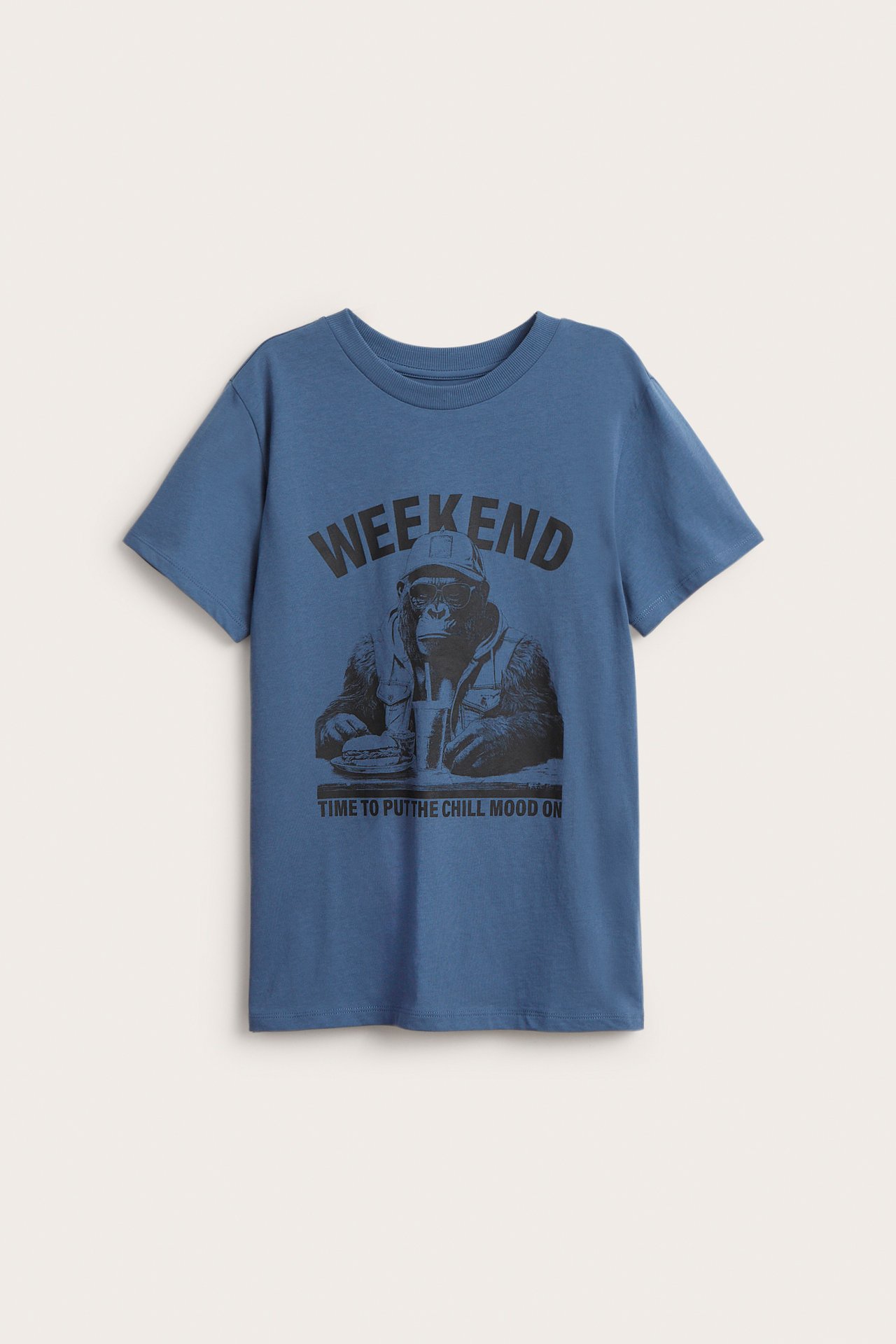 Frontvy av en blå bomulls-t-shirt för barn med schimpans-tryck och texten "WEEKEND".