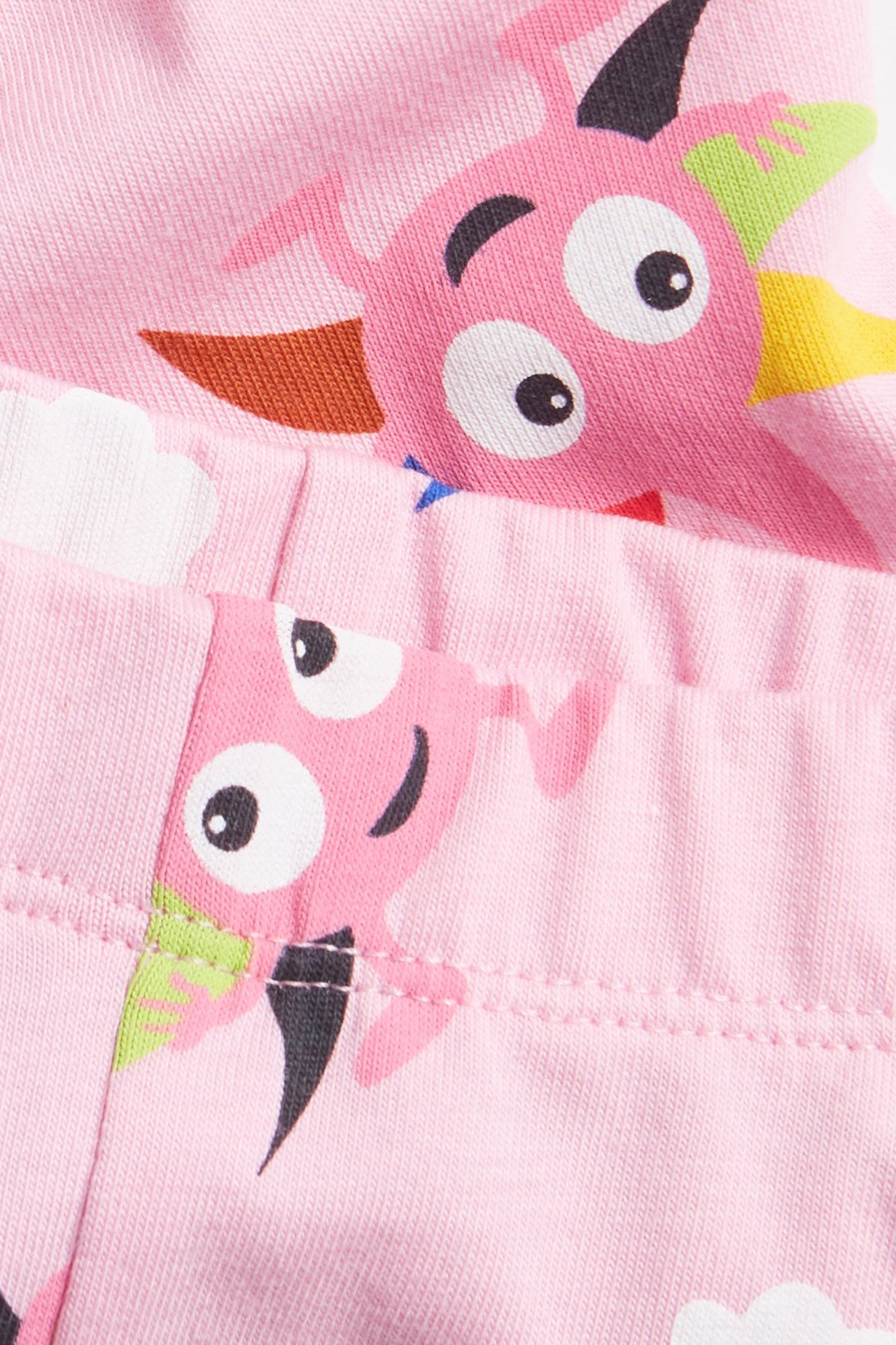 Zbliżenie różowych, wzorzystych spodenek rowerowych dla dzieci z kolorowymi motywami Diddi Babblarna.