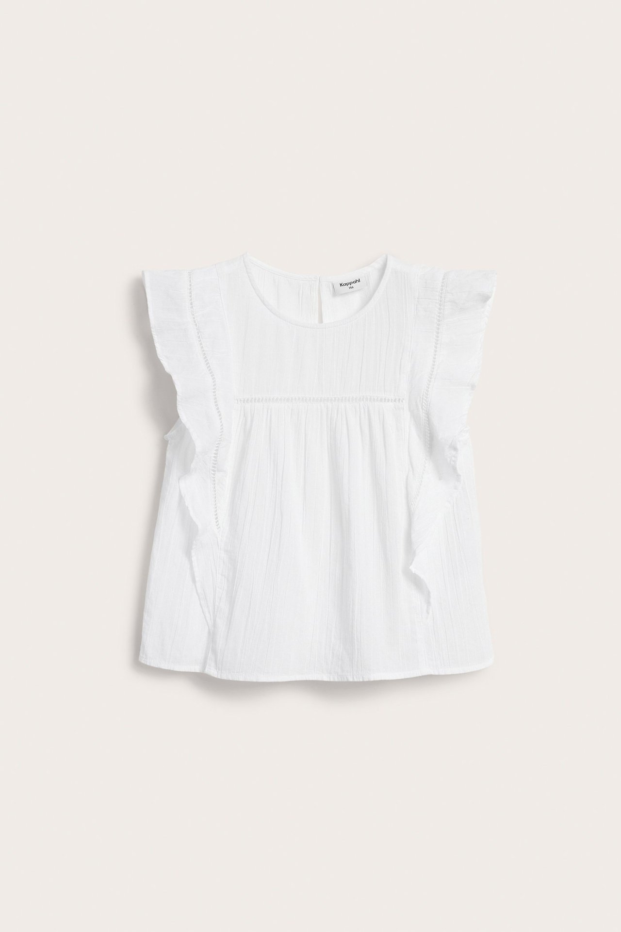 Forfra, hvit ermeløs barnebluse i vevd bomull med volangermer og blondedetaljer på bærestykket.